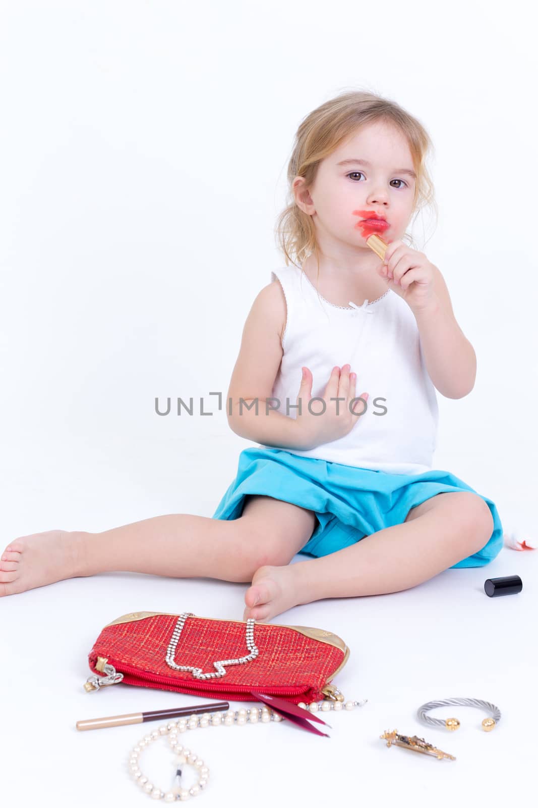 Adorable small girl playing with makeup by coskun