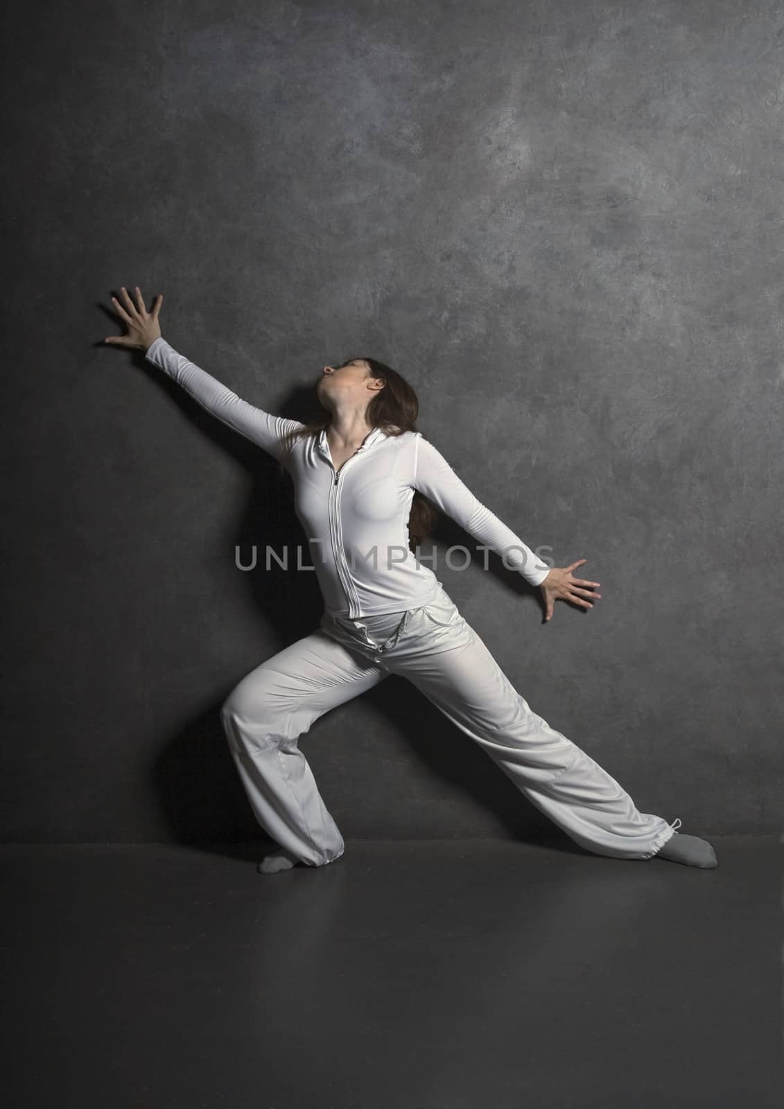 Young woman posing against gray concrete wall