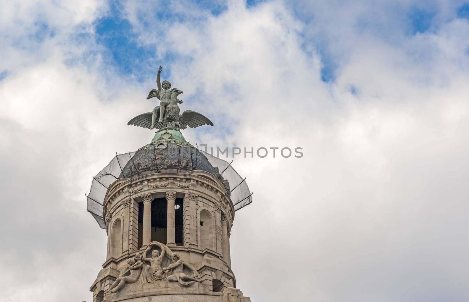 An old domed apartment building in Barcelona with winged angel on roof 