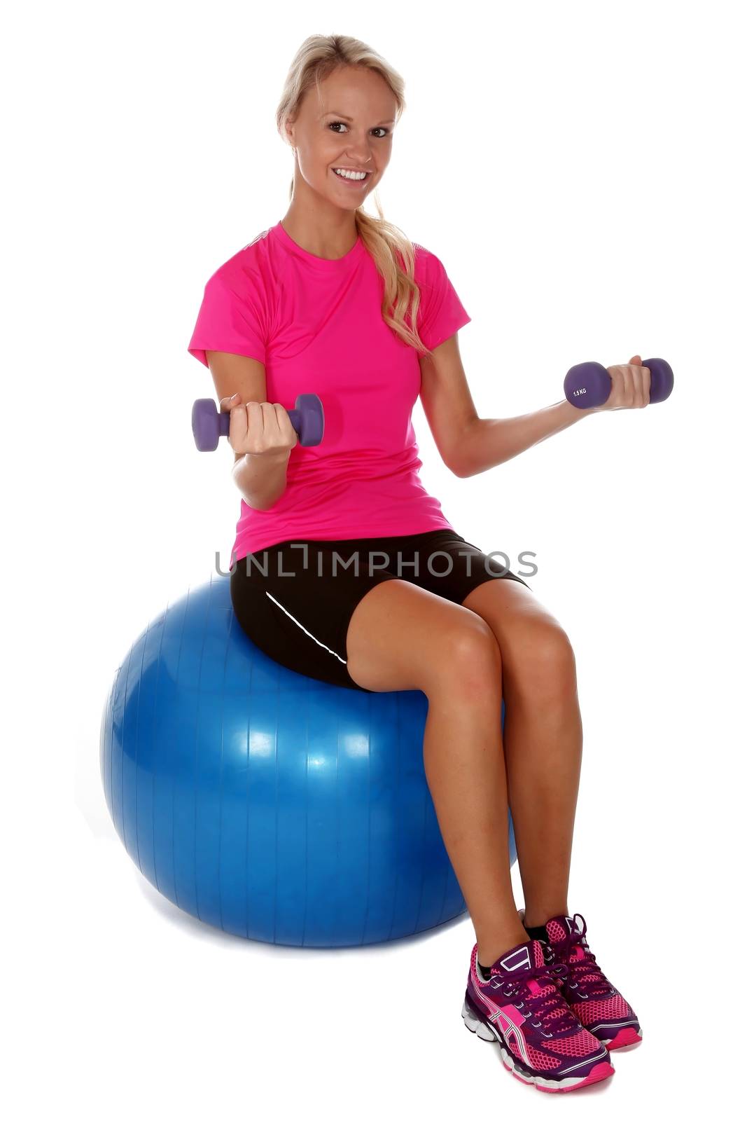 Beautiful young lady doing gym exercises on an inflated rubber ball
