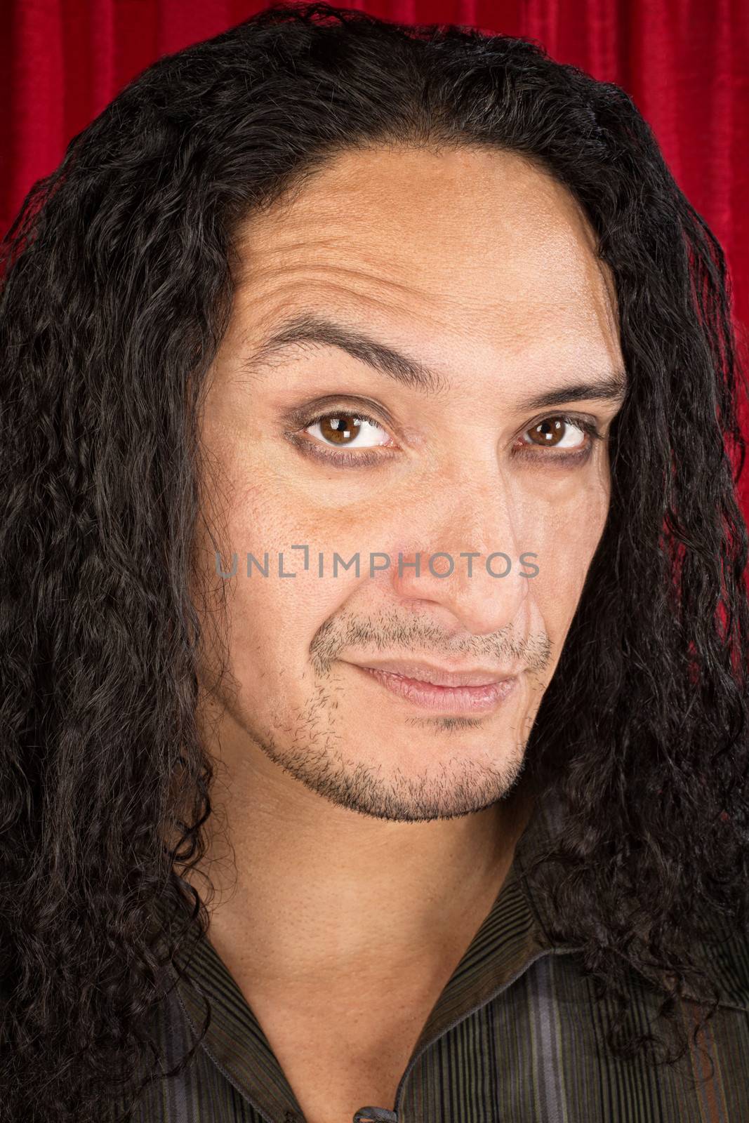 Close up of skeptical Latino man with long hair