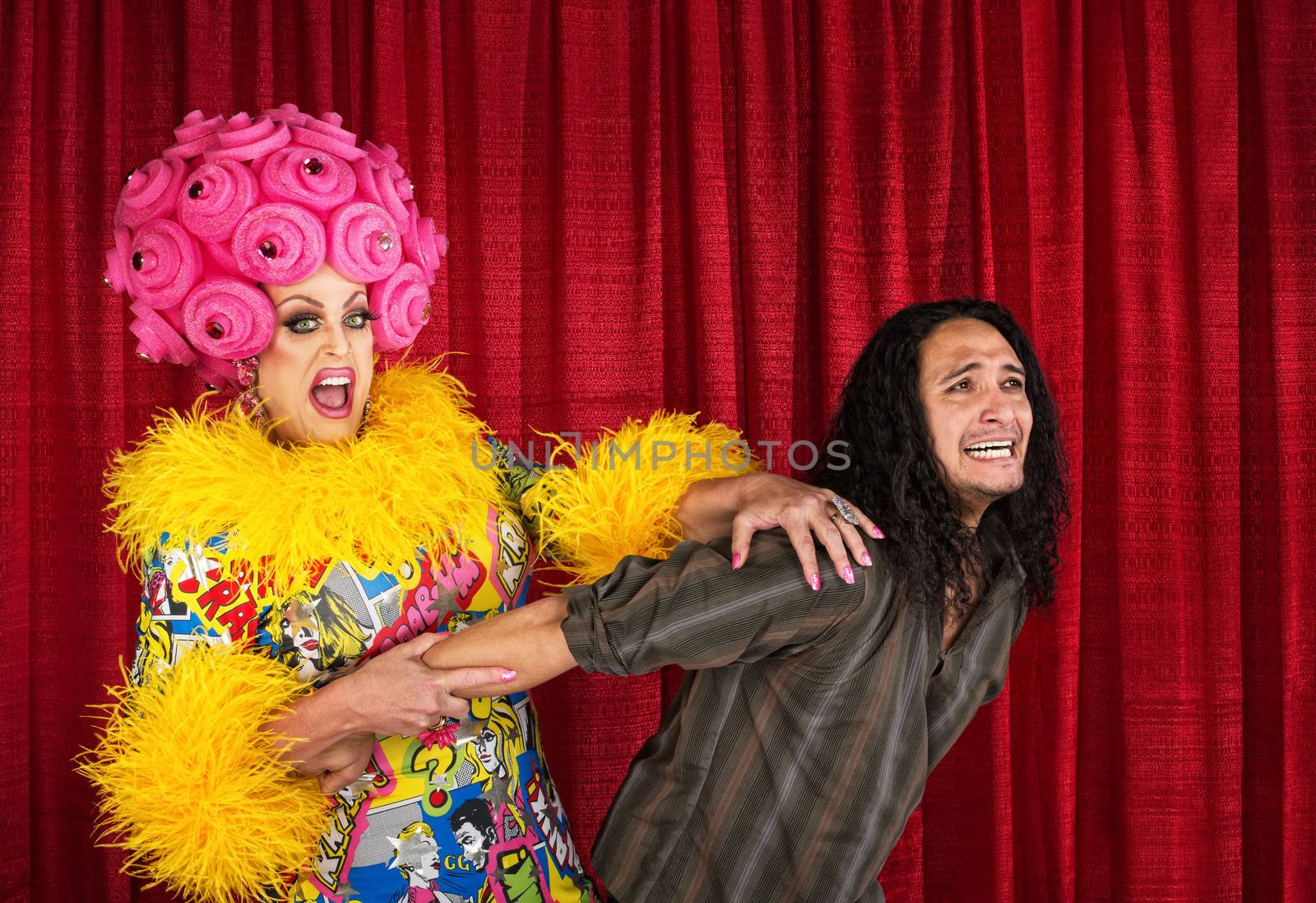 Excited cross-dressing queen pulling on scared man