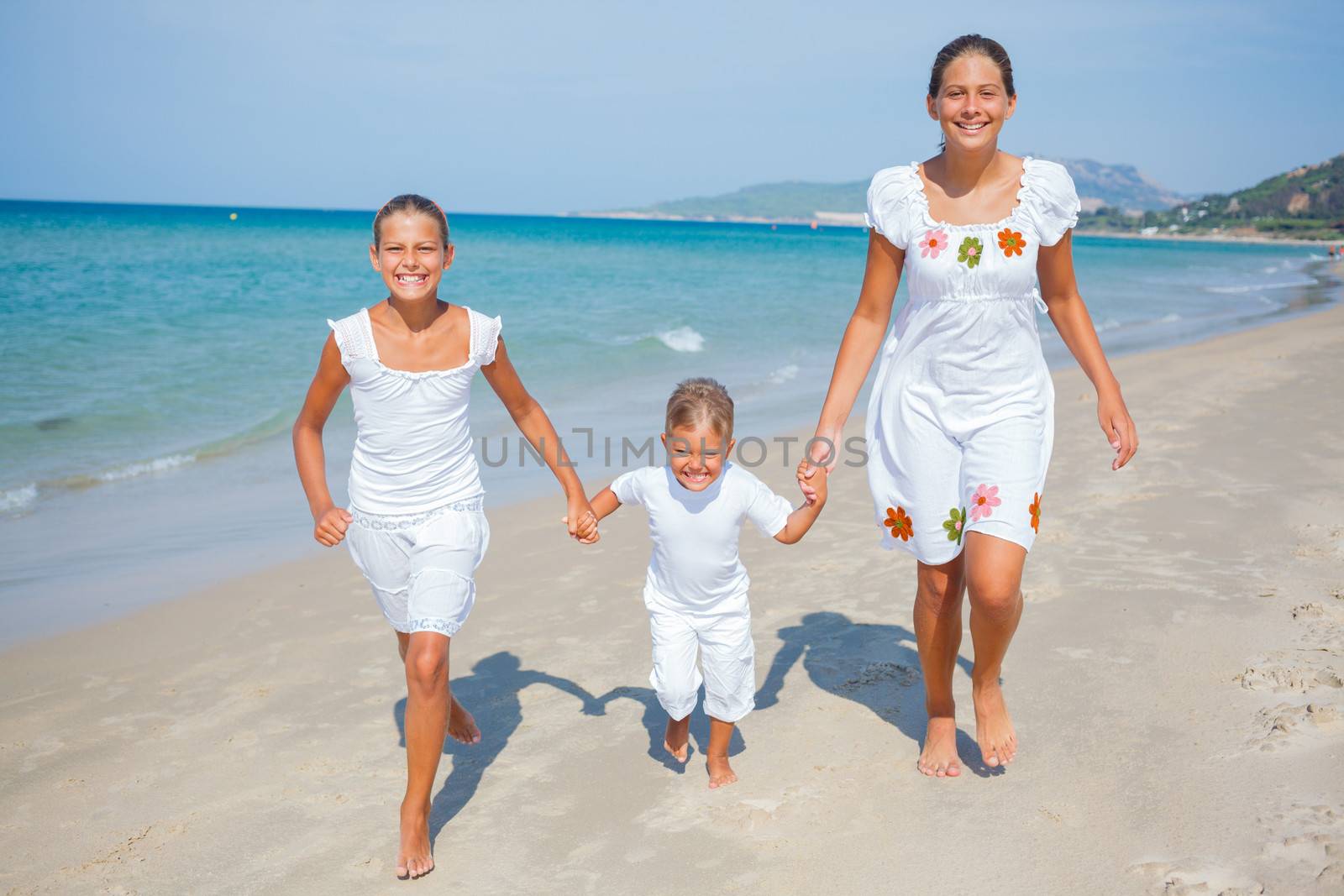 Adorable happy boy and girls running on beach vacation