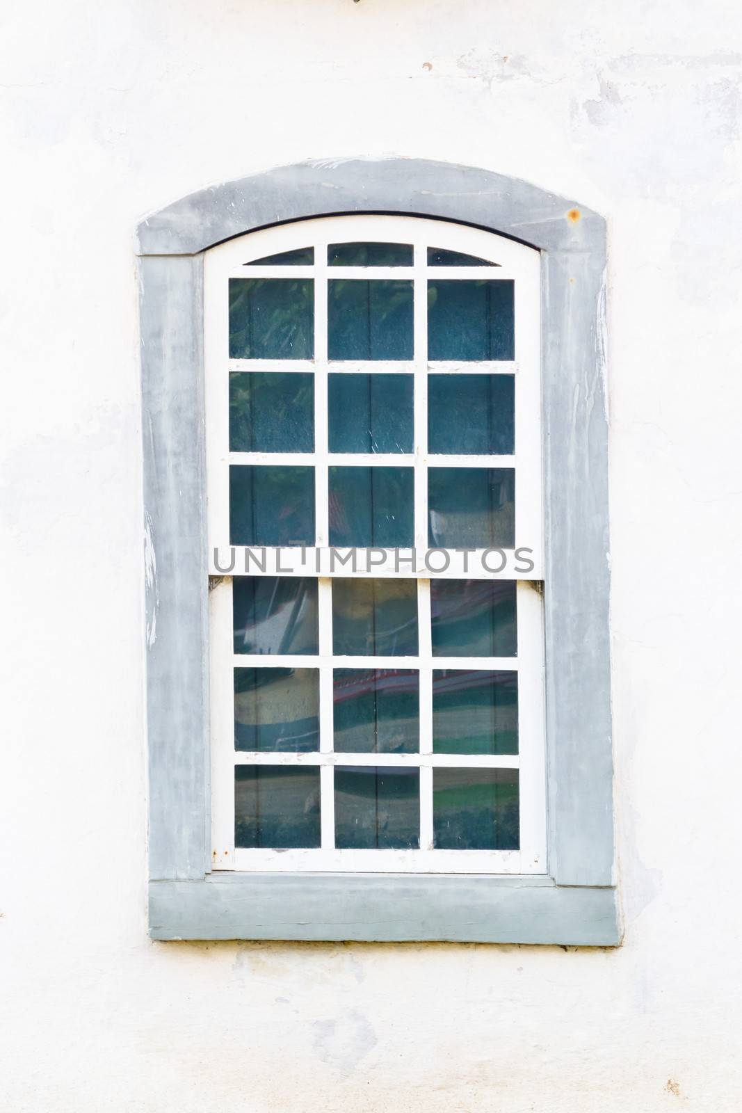 Decorative, colonial, grey, vintage, window on a white wall in Paraty (or Parati), Brazil.
