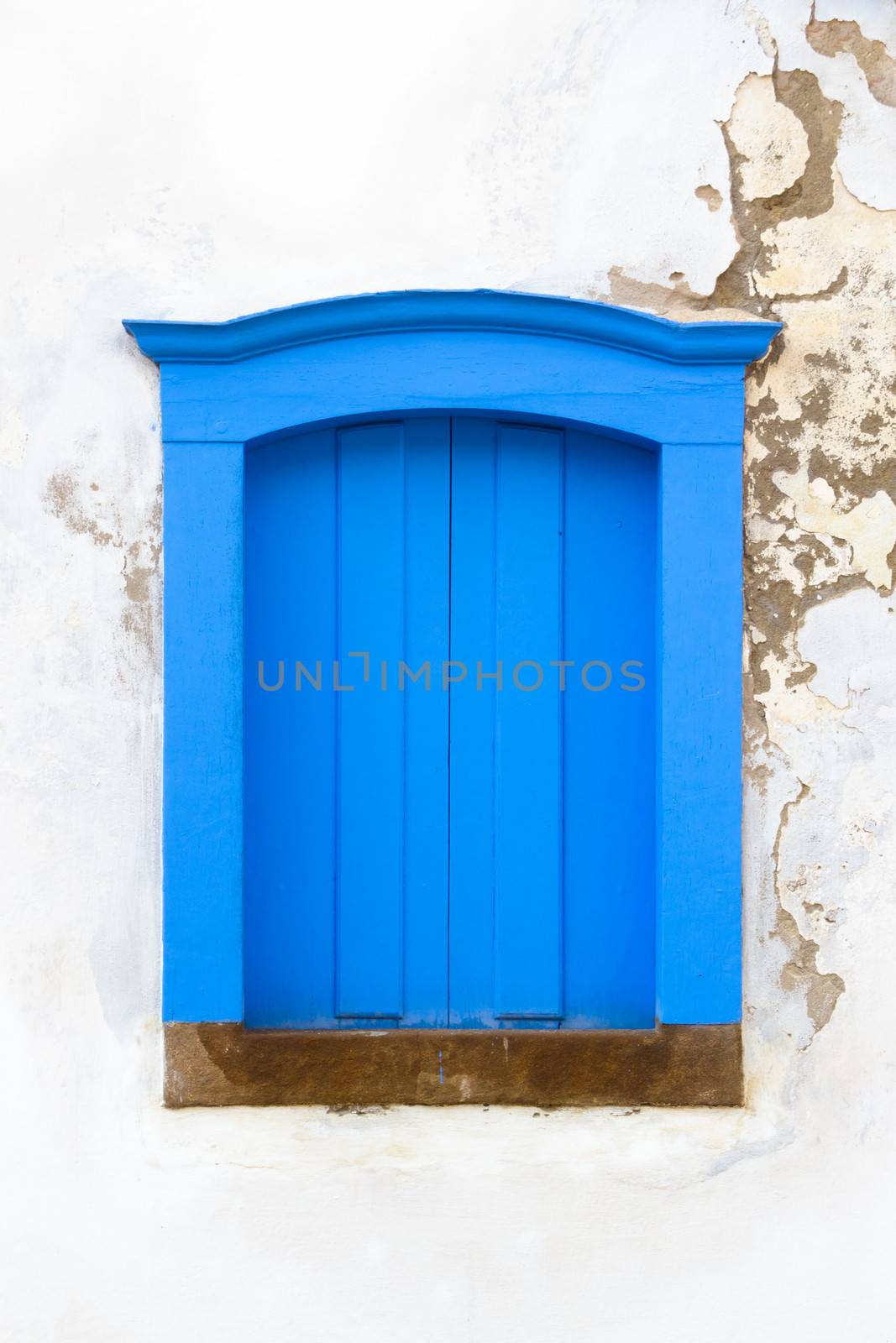 Decorative, colonial, blue, vintage, window on a white wall in Paraty (or Parati), Brazil.