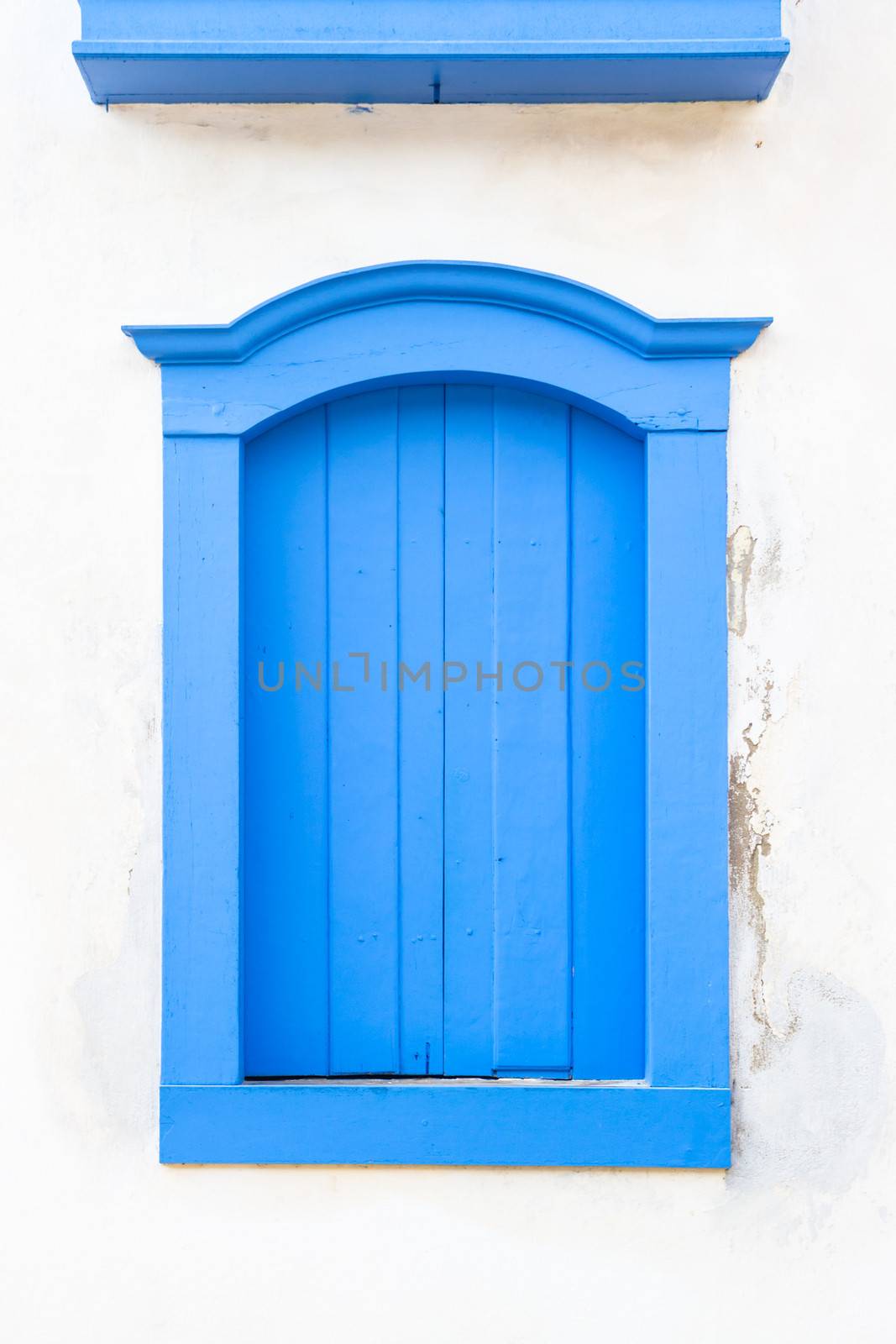 Decorative, colonial, blue, vintage, window on a white wall in Paraty (or Parati), Brazil.