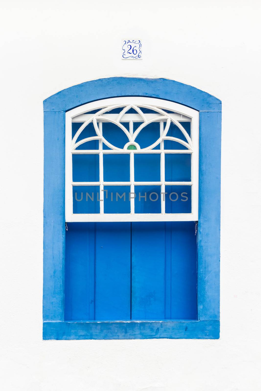 Decorative, colonial, blue, vintage, window on a white wall in Paraty (or Parati), Brazil.