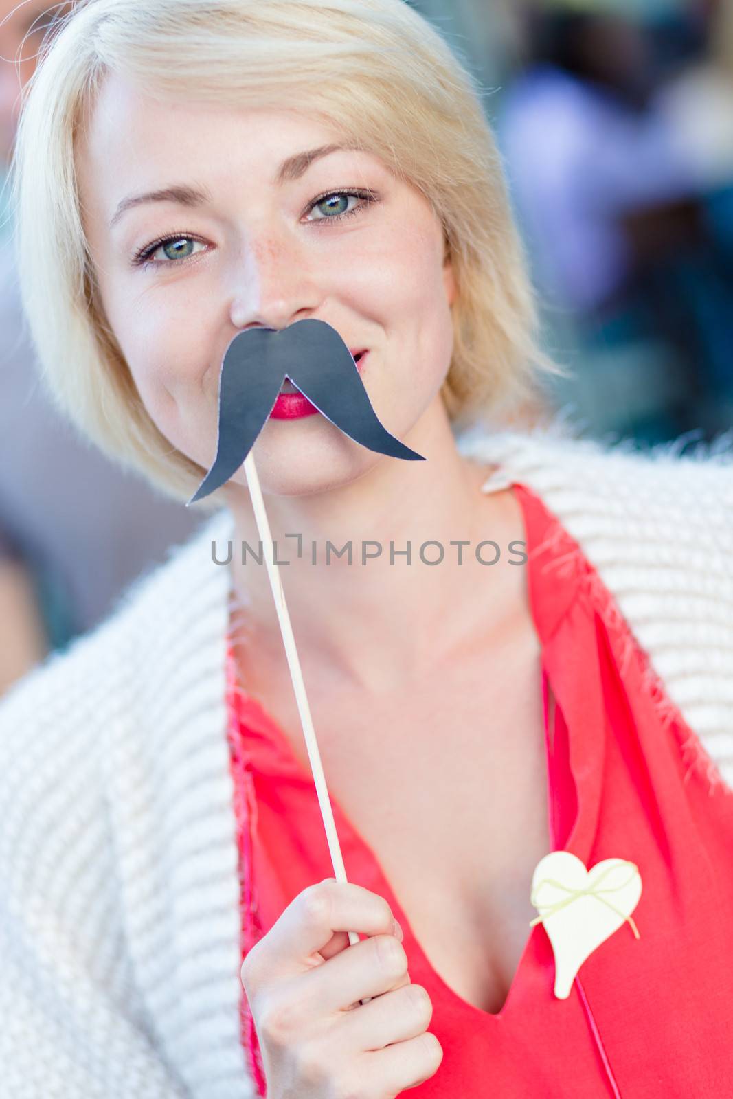 Portrait of girl wearing fake mustache: symbol of Movember, annual, month-long event involving the growing of moustaches during the month of November to raise awareness of men's health issues.
