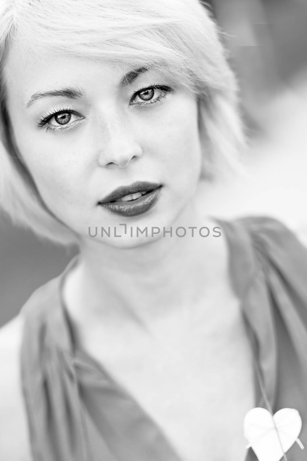 Black and white portrait of a self-confident woman shot outside in the garden.