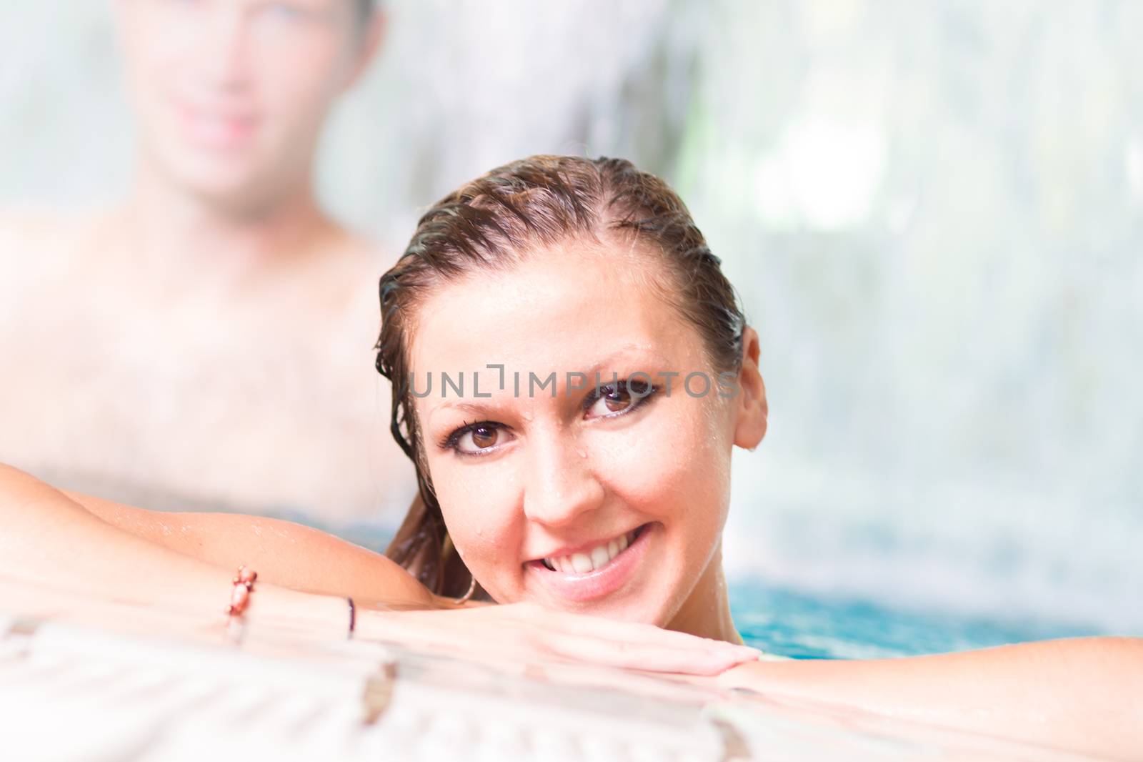 Young couple relaxing in the indoor swimming pool.