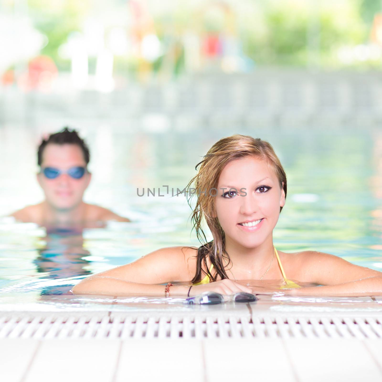 Young couple in the swimming pool. by kasto