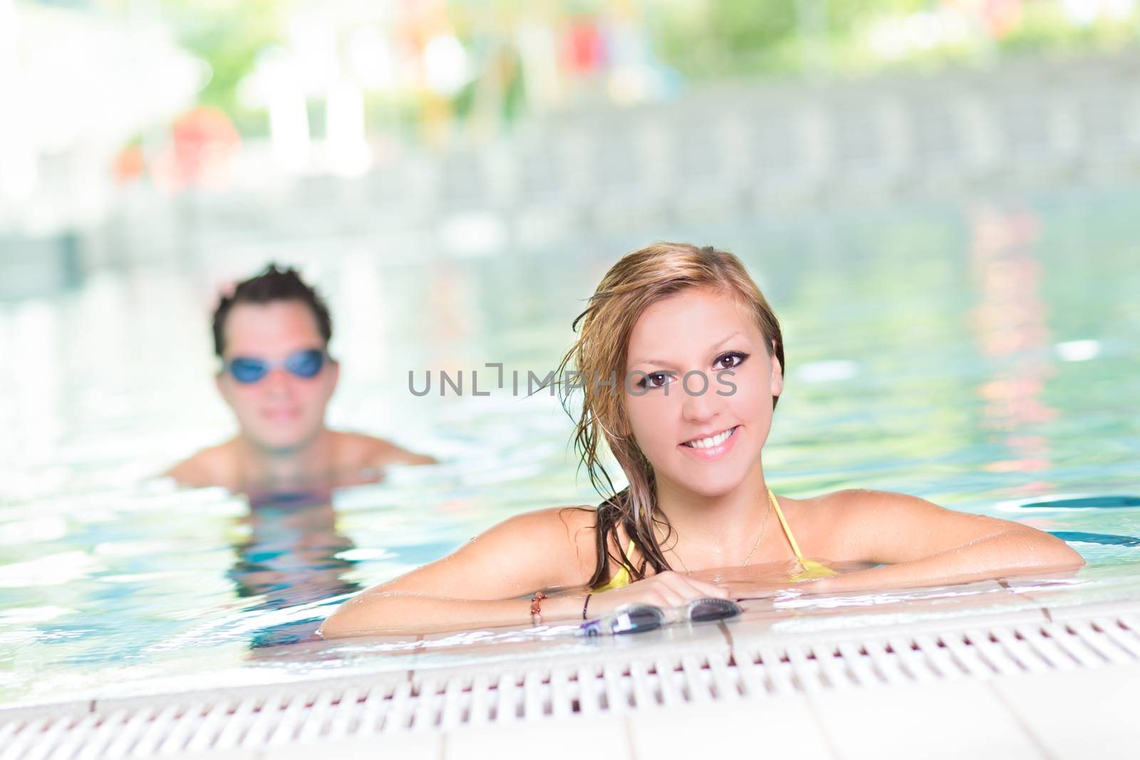 Young couple relaxing in the indoor swimming pool.