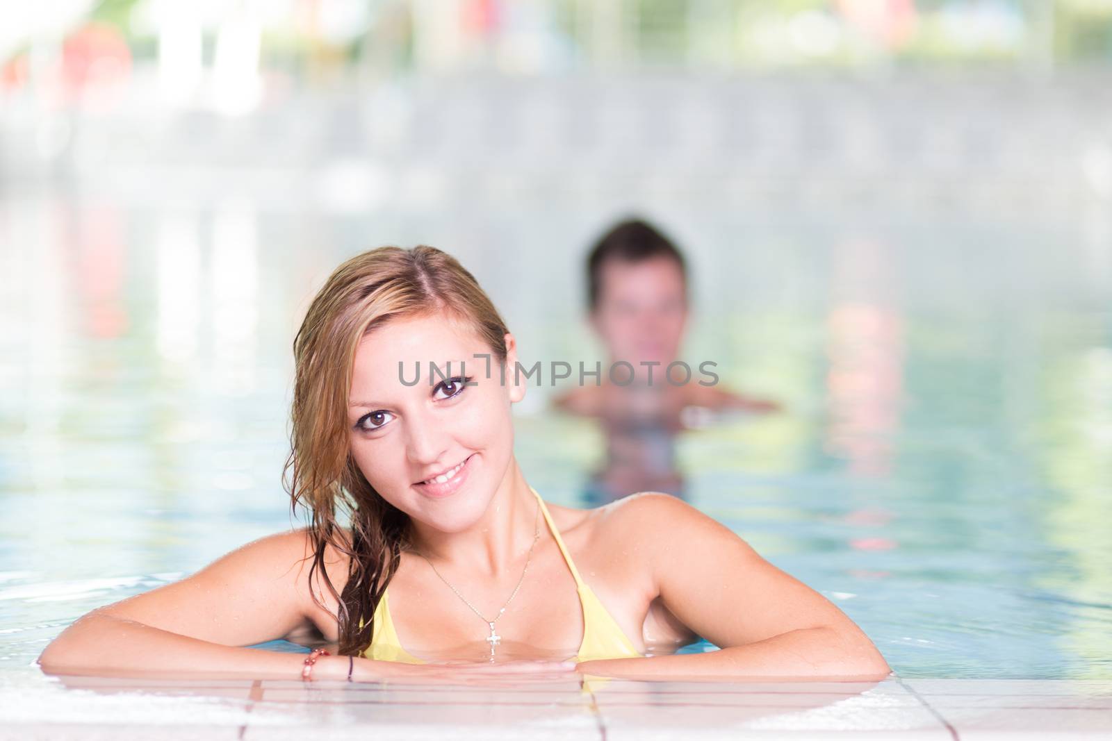 Young woman relaxing in the indoor swimming pool.