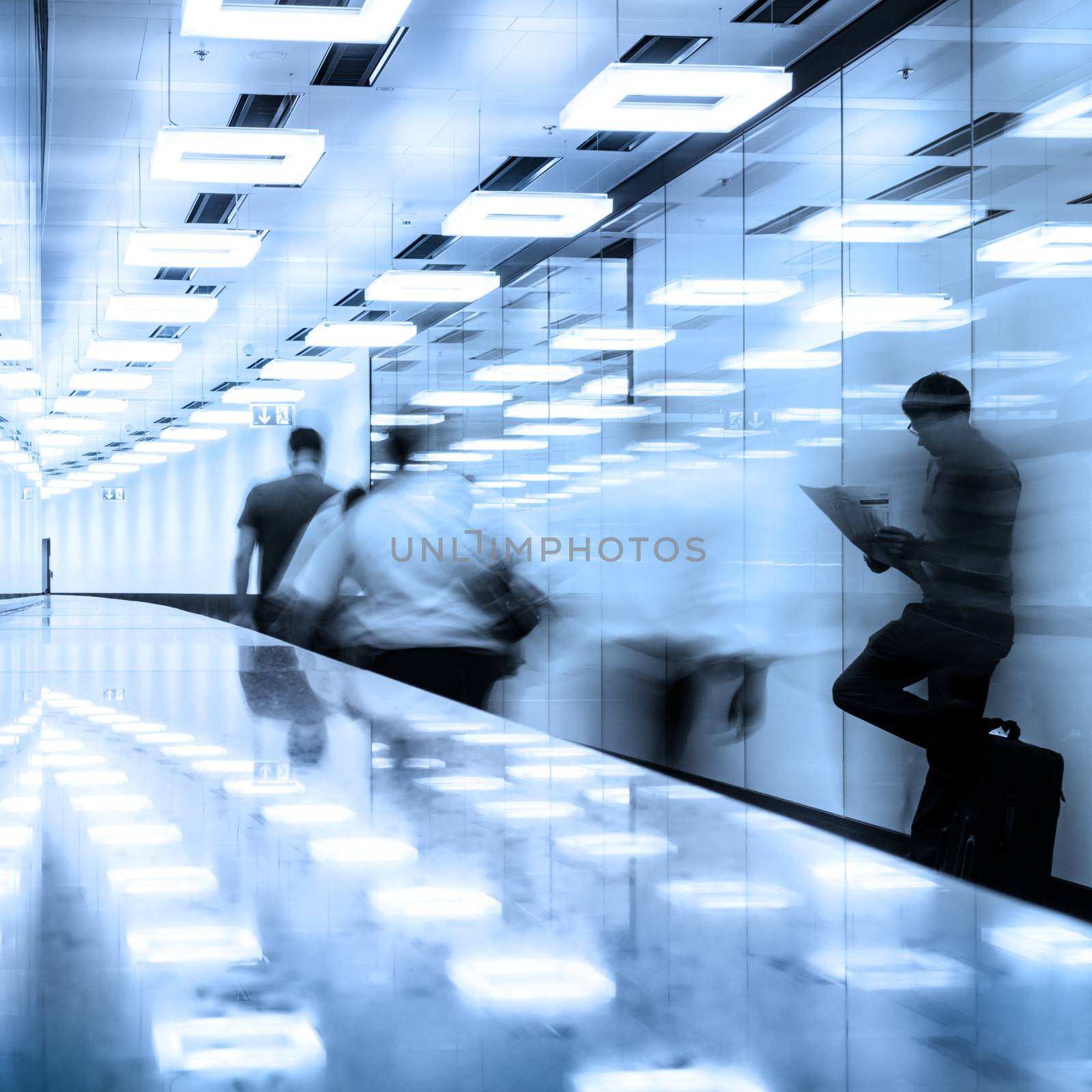 Business travelers in airport terminal hall. by kasto