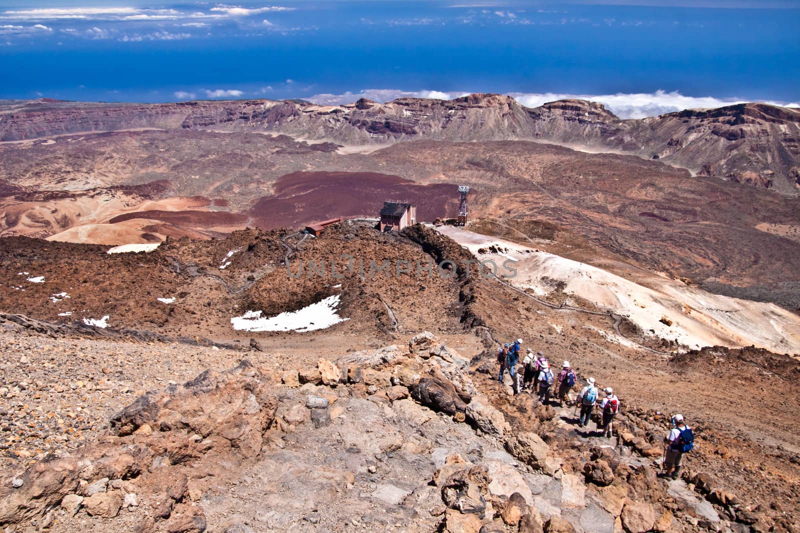 Group of senior hikers backpacking in the rough  volcanic landscape on the volcano, Teide, highest peak of Spain.