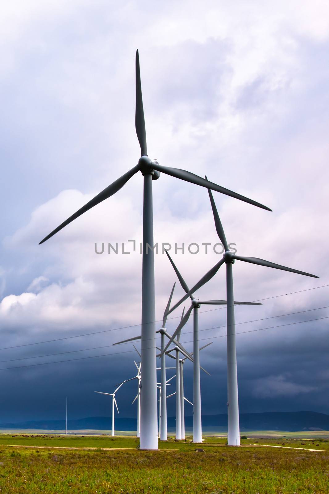 Wind turbines generating electricity in a stormy weather.