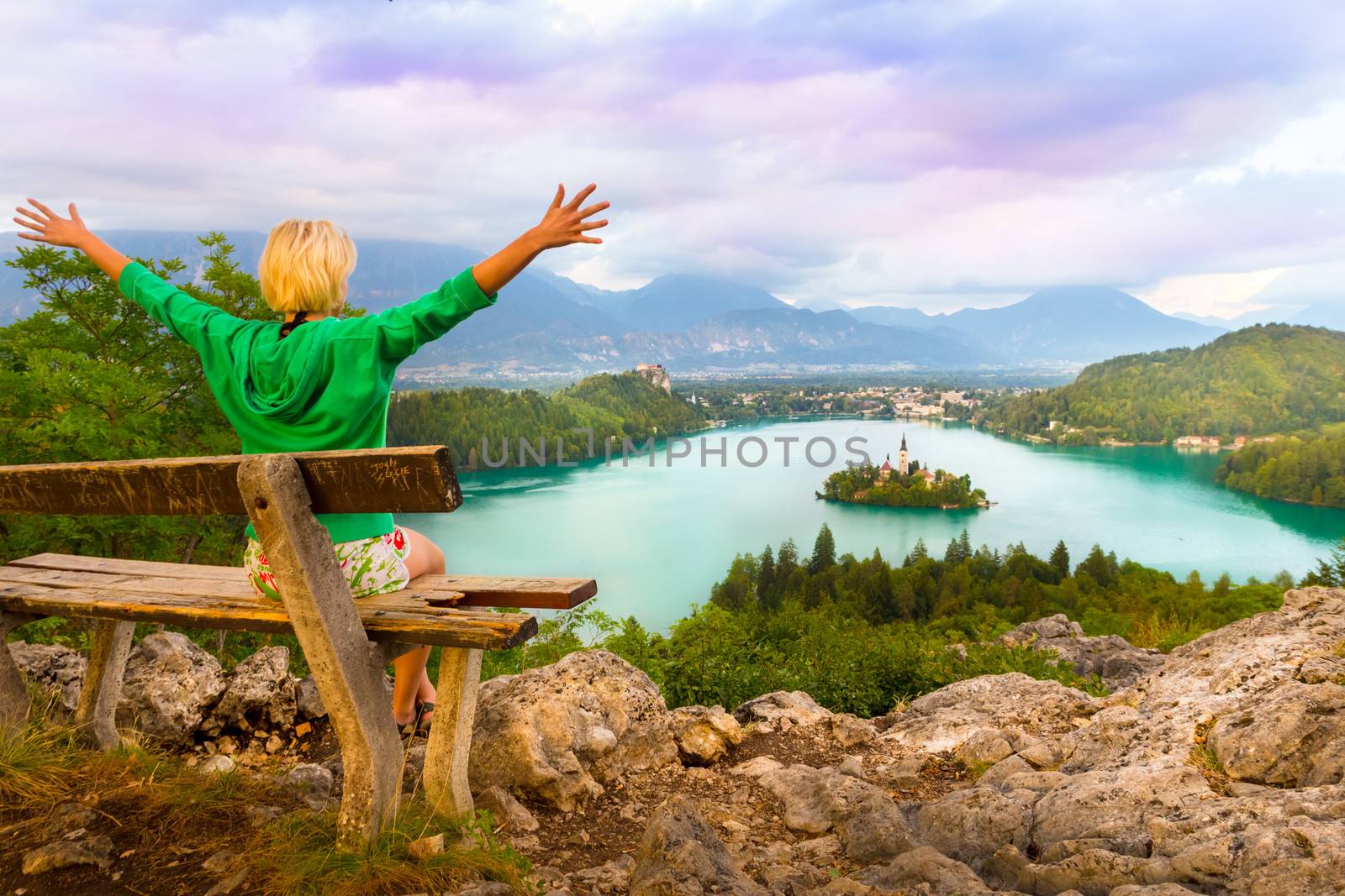 Traveler enjoying the sunset panoramic view of  Julian Alps, Lake Bled with St. Marys Church of the Assumption on the small island; Bled, Slovenia, Europe.