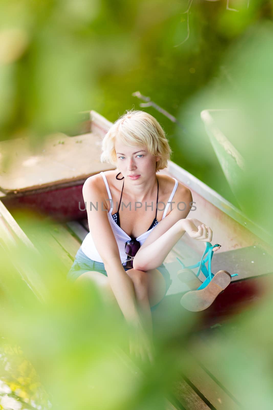 Woman relaxing on the vintage wooden boat. by kasto