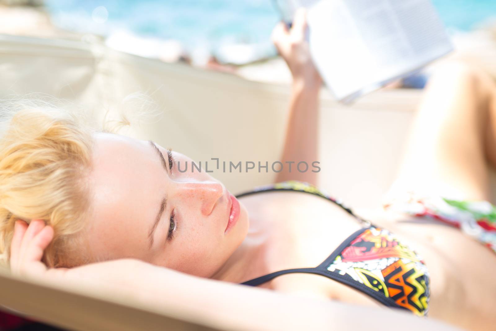 Thoughtful woman lies on hammock on the beach. by kasto