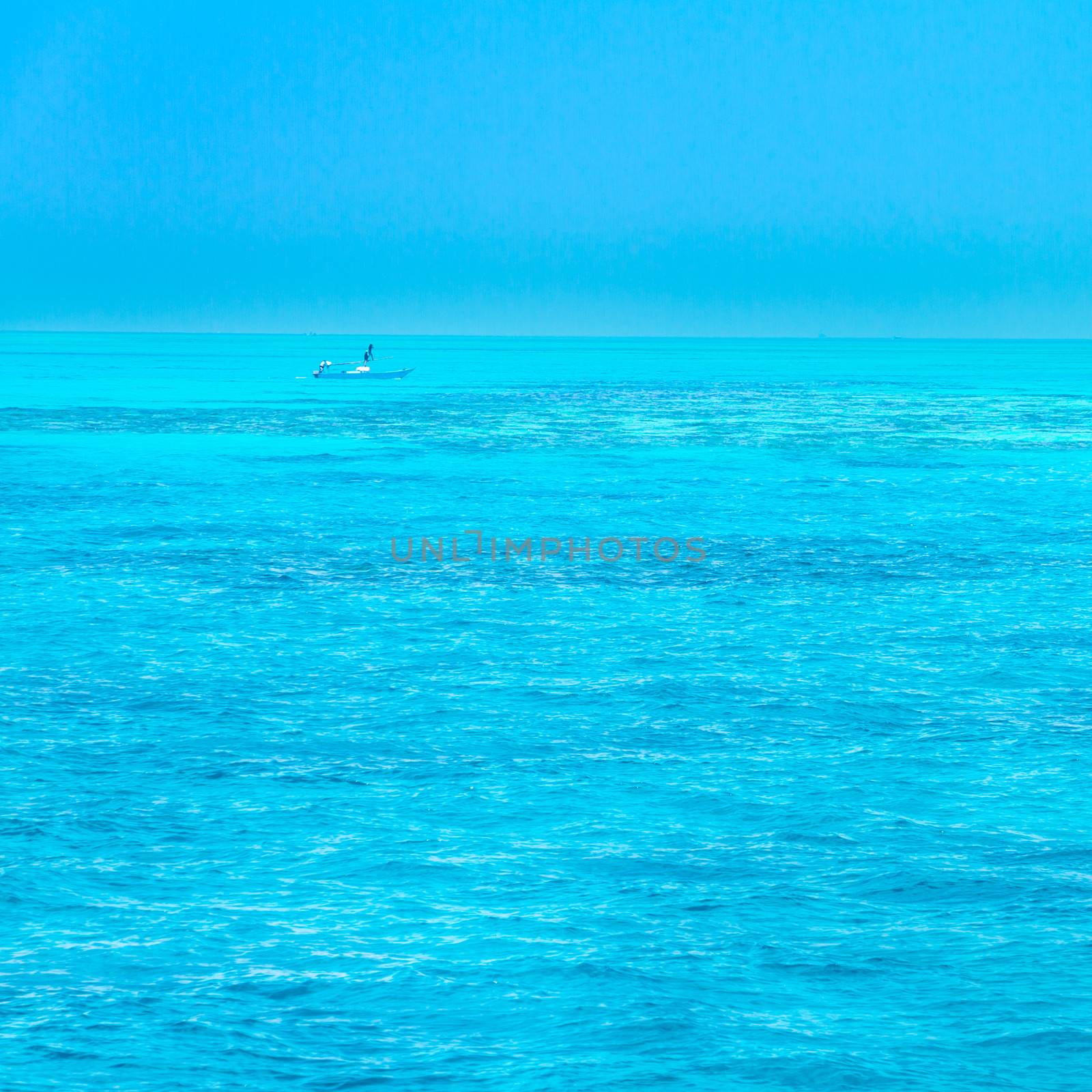 Turquoise coral reef in red sea. Fisherman's boat in the background.
