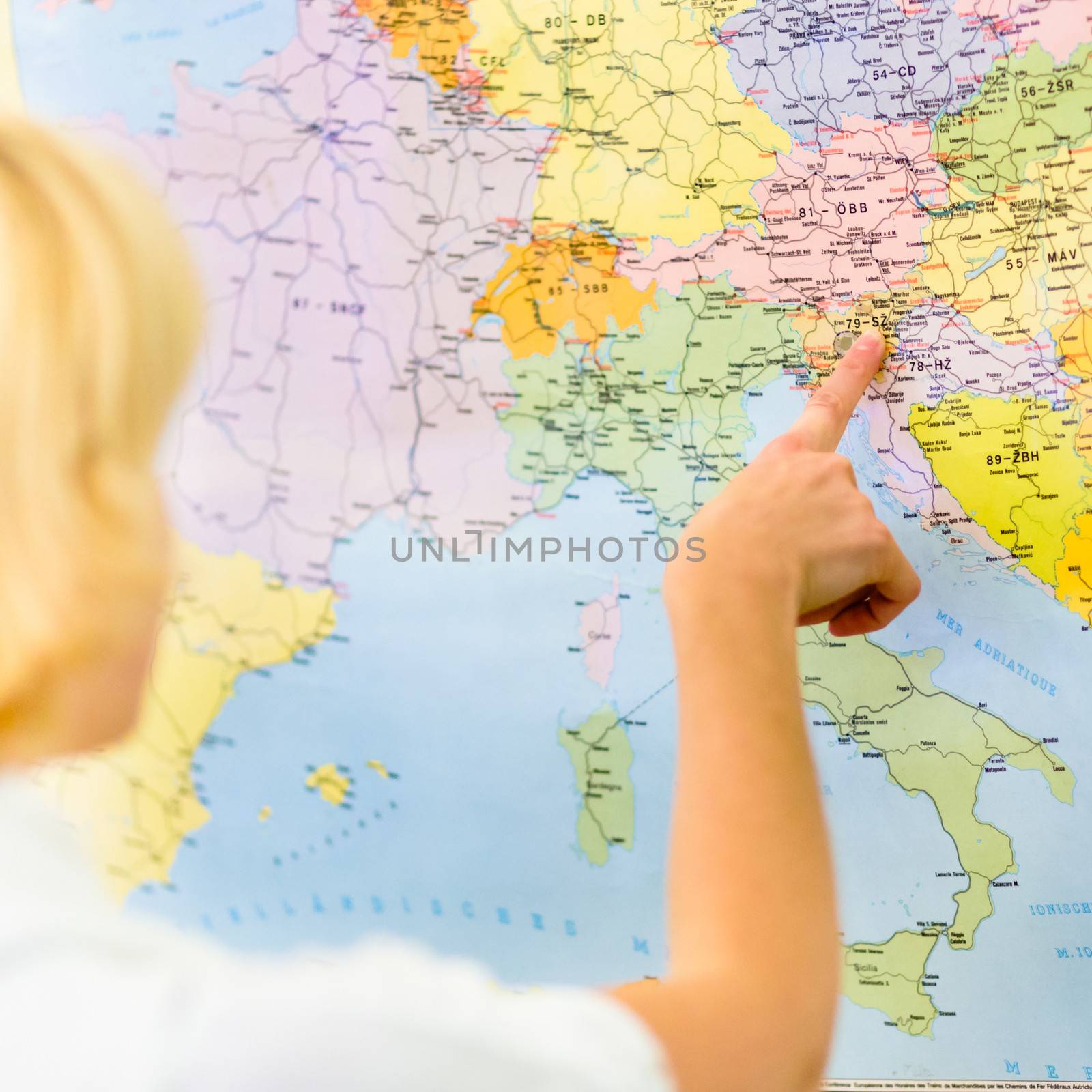 Caucasian teacher pointing Slovenia on the map of European countries.