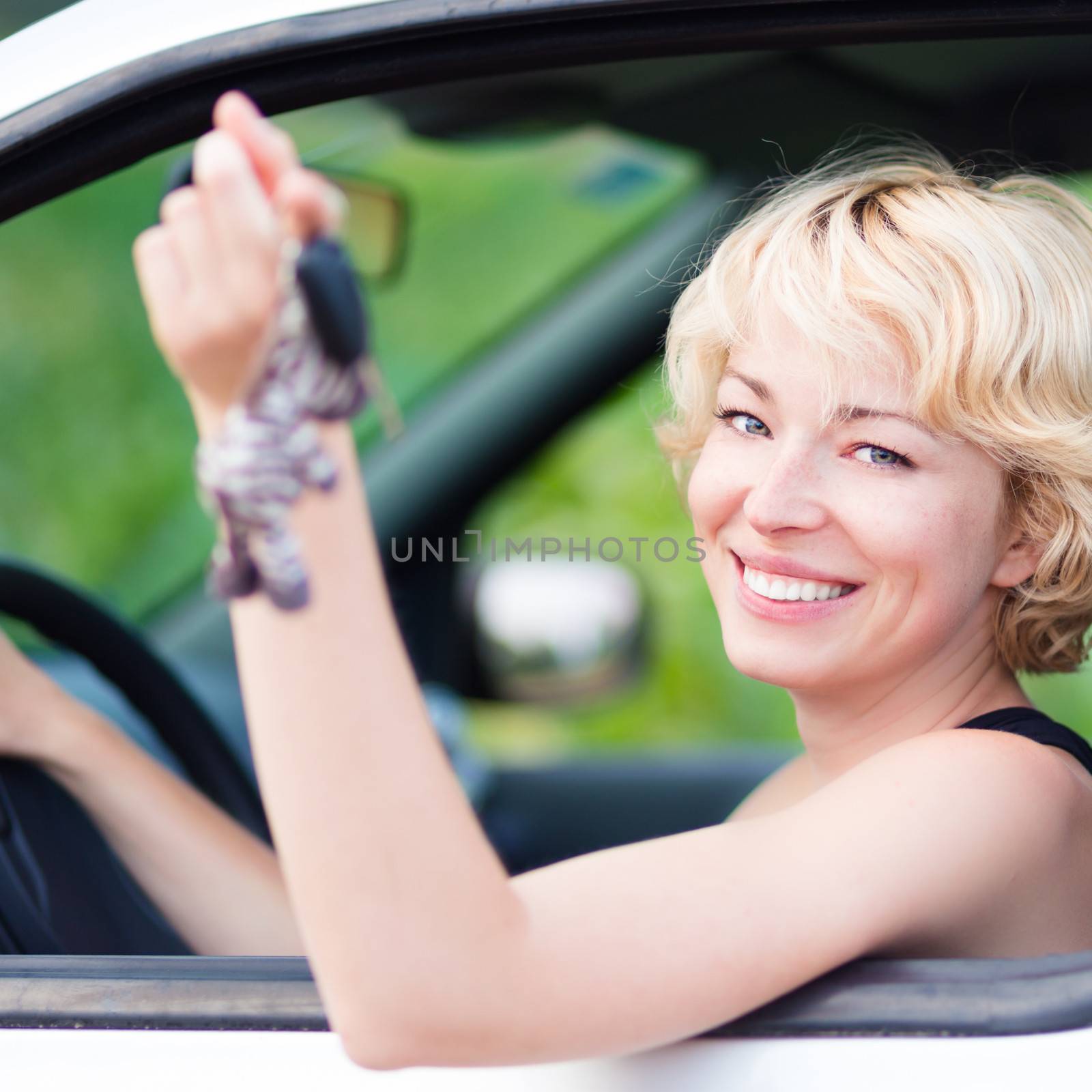 Lady, driving showing car keys out the window.  by kasto