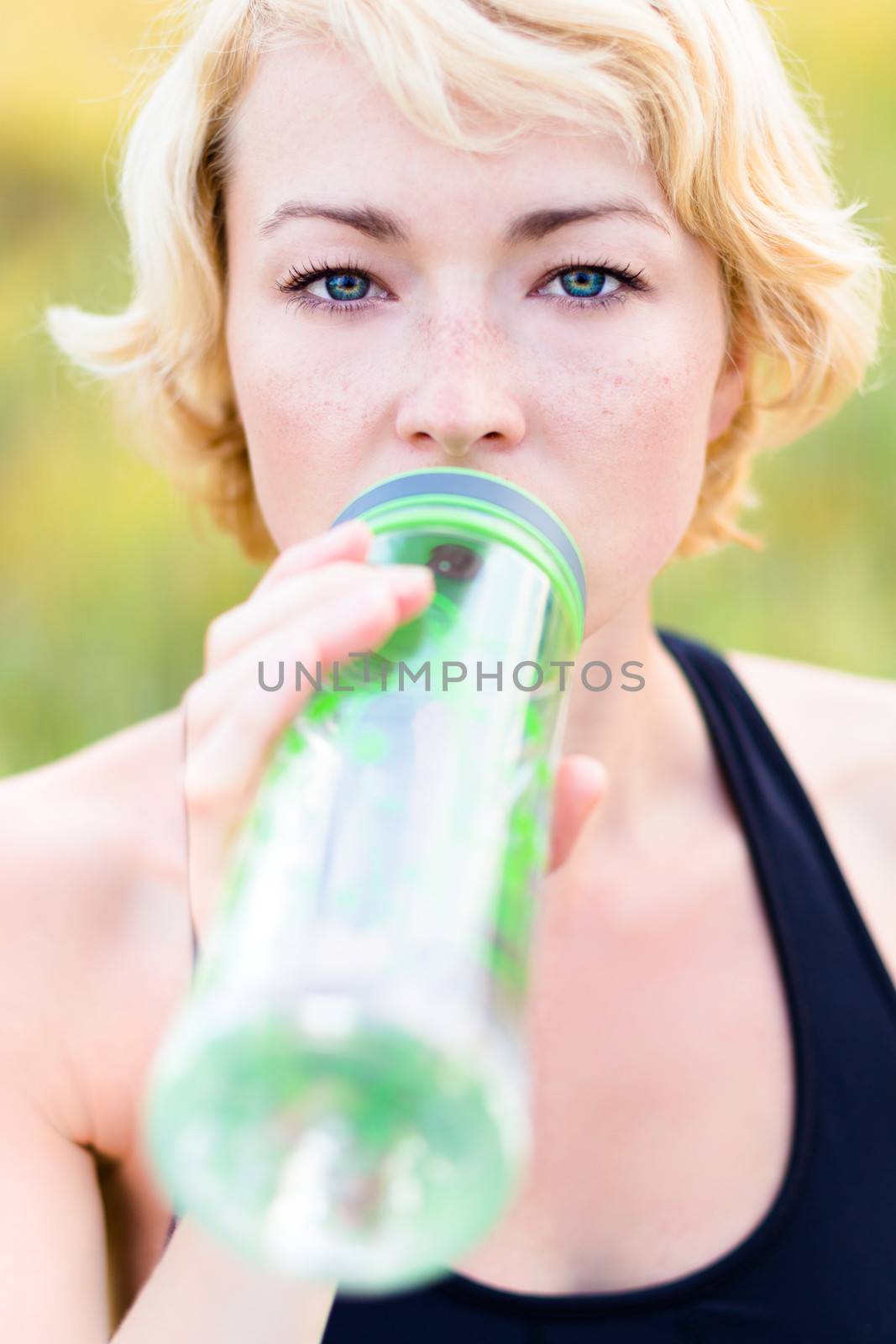 Lady drinking from the bottle during outdoor activities.