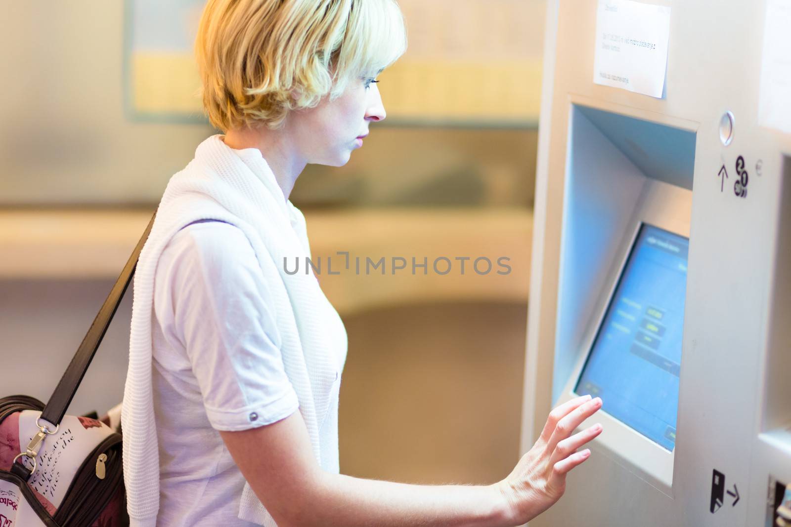 Lady using ticket vending machine. by kasto