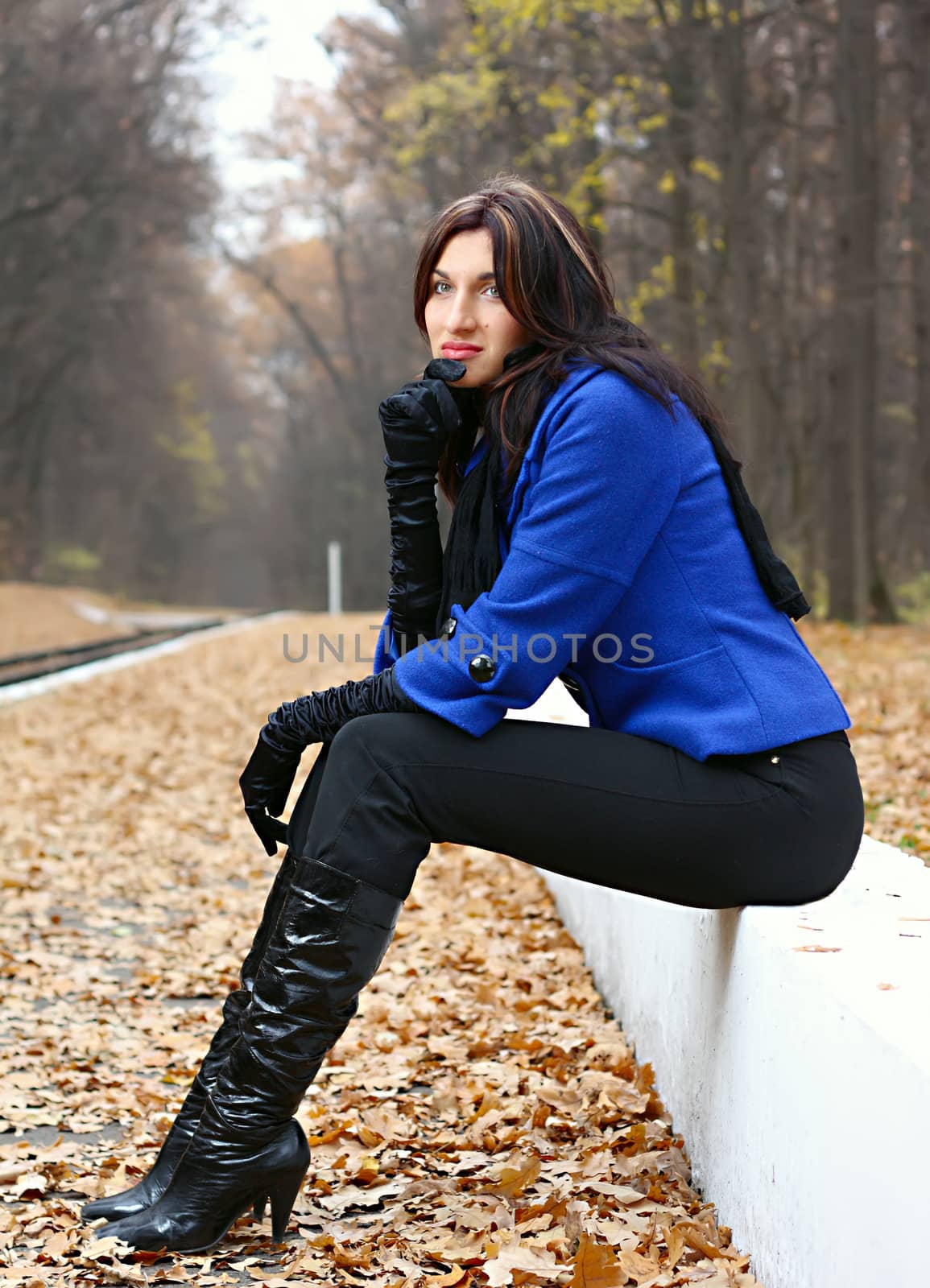 Young woman sitting in the autumn park