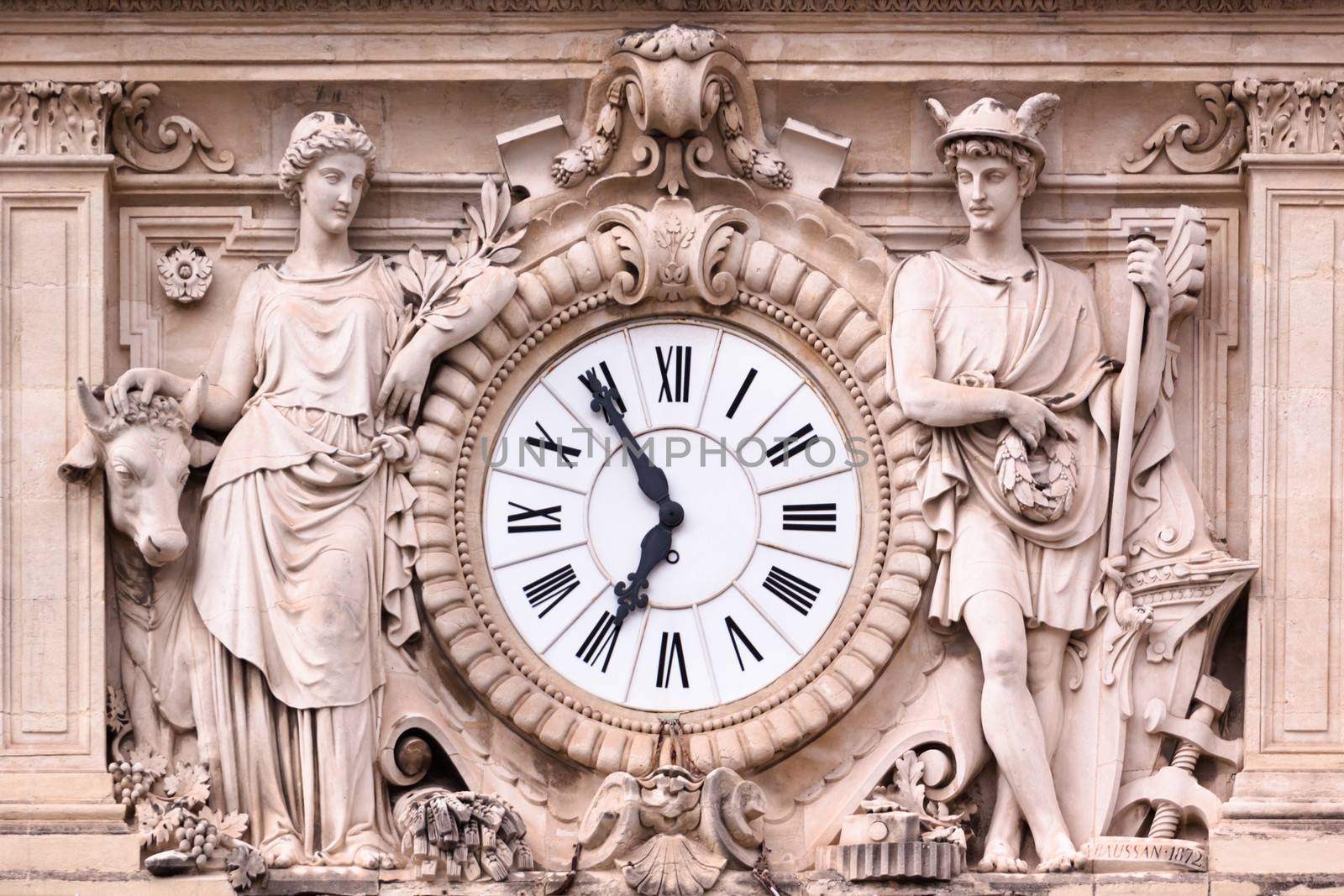 Antic ornate clock on one of the medieval hose facades in Montpellier, south France, Europe