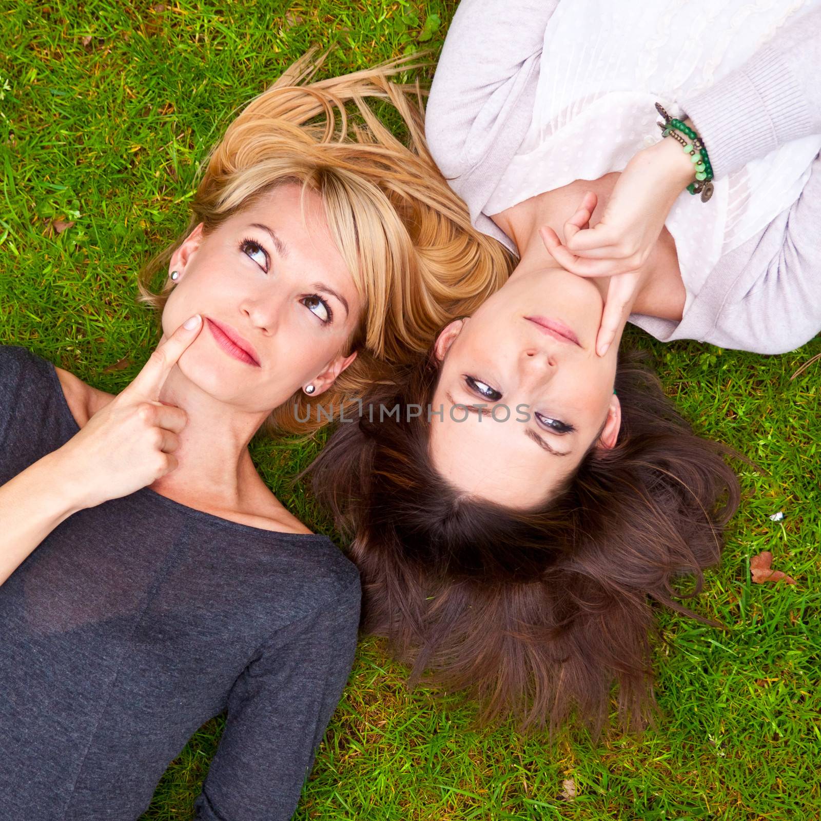 Two girls lying in the grass by kasto