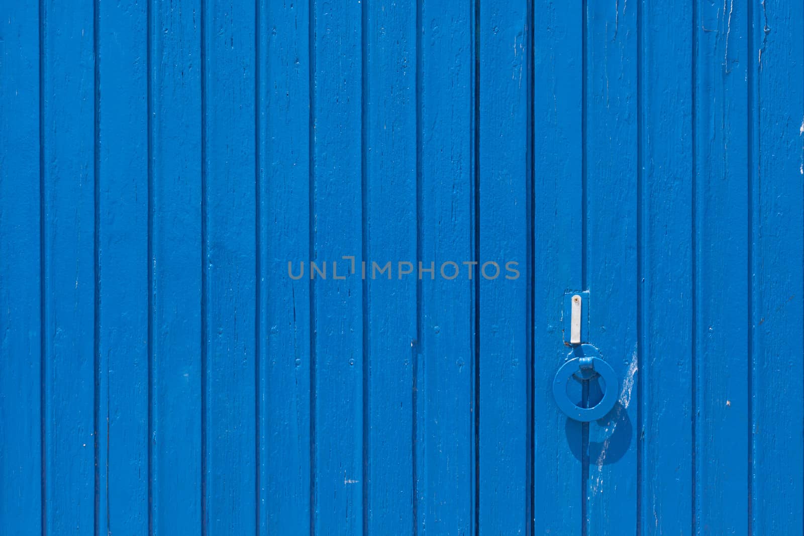 Aged grunge weathered blue door. Can be used as a Mediterranean background.