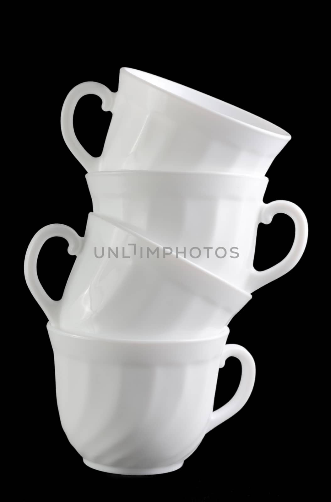 Pile of white cups isolated at the dark background