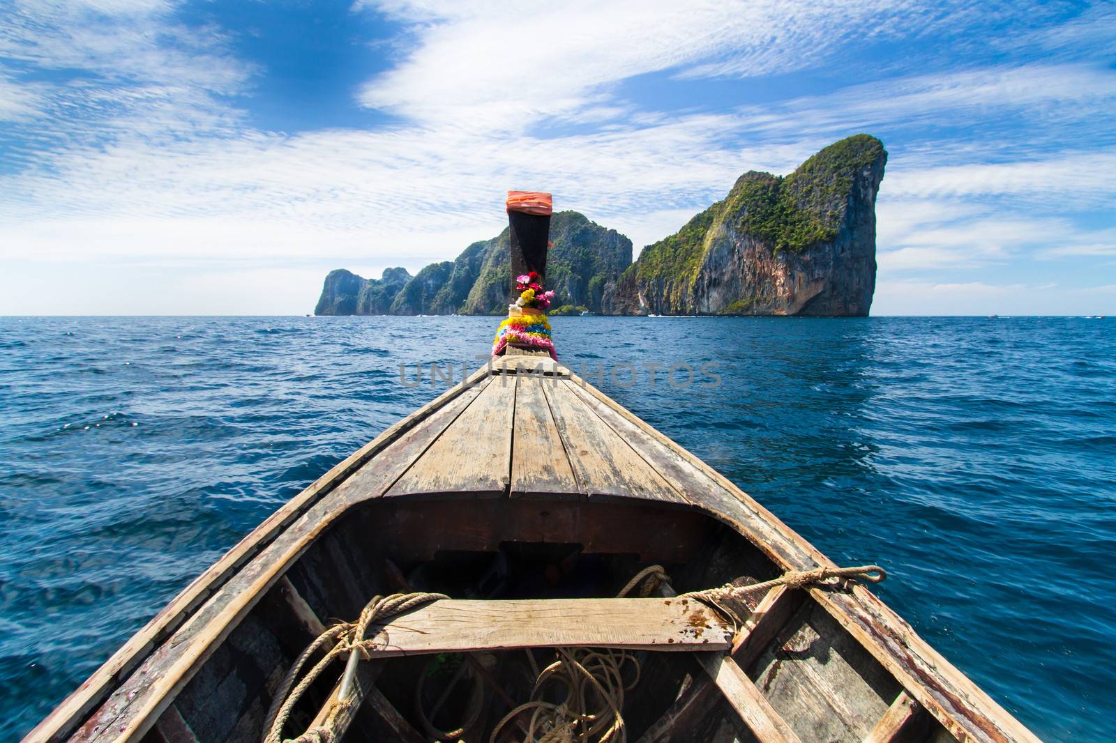 Traditional wooden  boat approaching picture perfect tropical Koh Phi Phi island, Thailand, Asia.