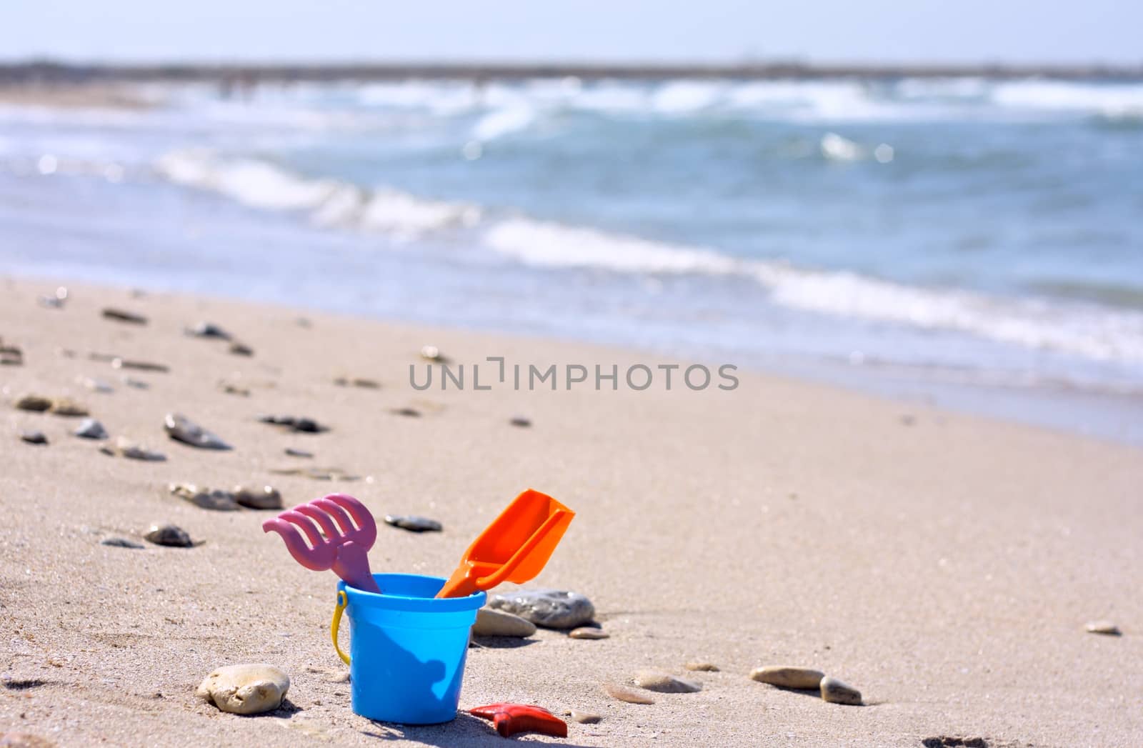Plastic bucket on the beach near the sea
