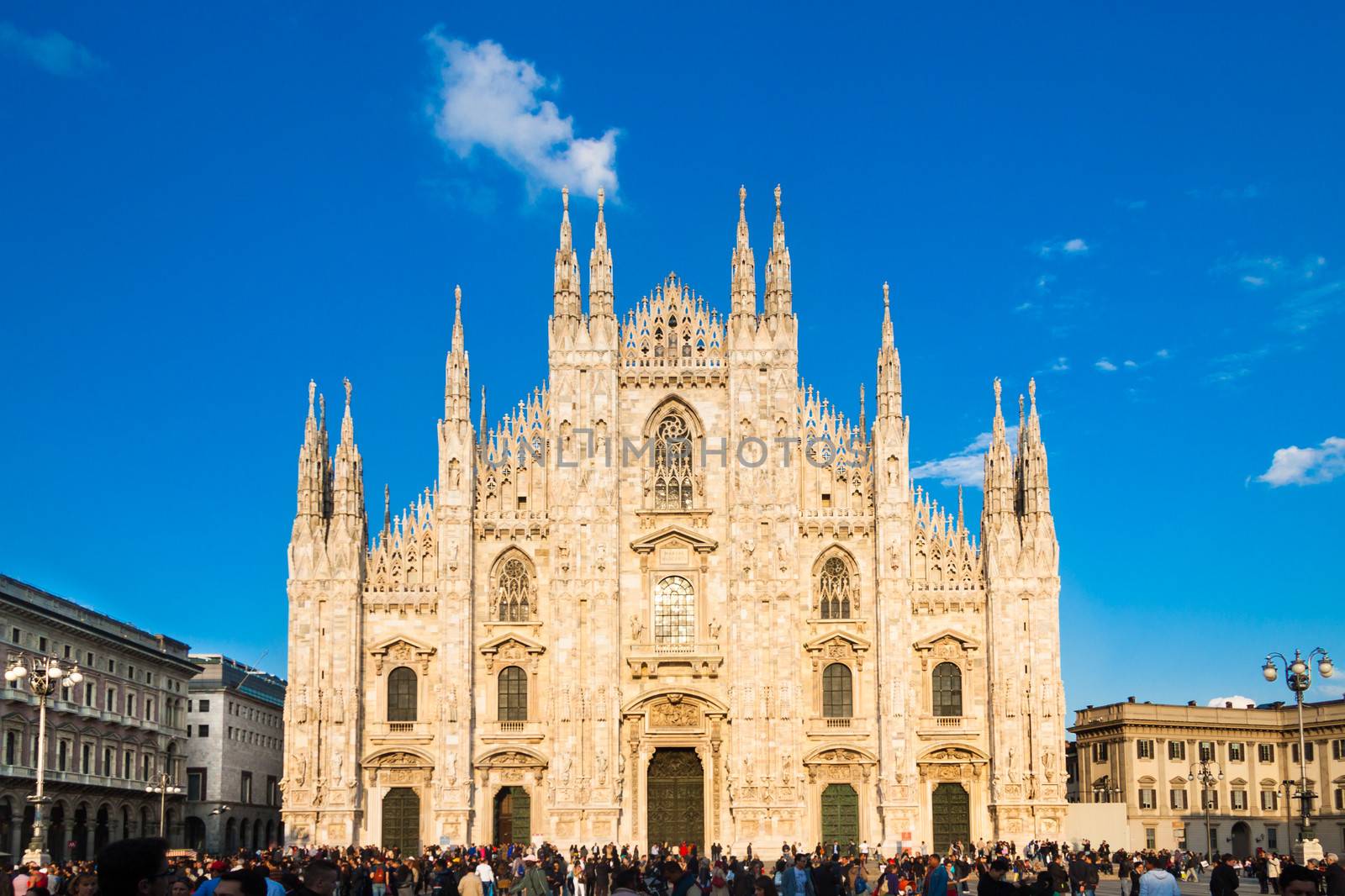 Milan Cathedral (Duomo di Milano) is the gothic cathedral church of Milan, Italy. Shot in the dusk from the square ful of people.