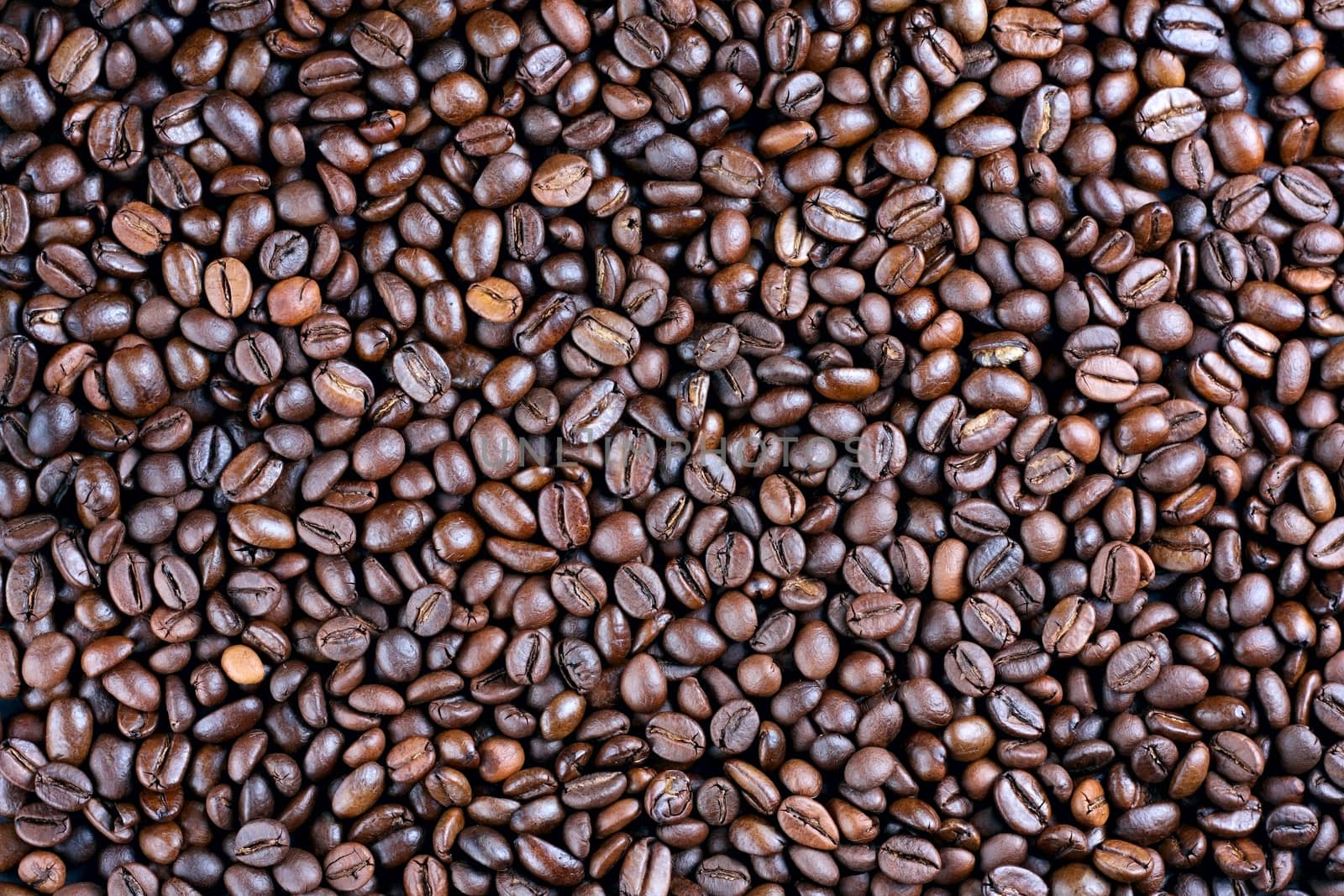 Many roasted coffee beans at background