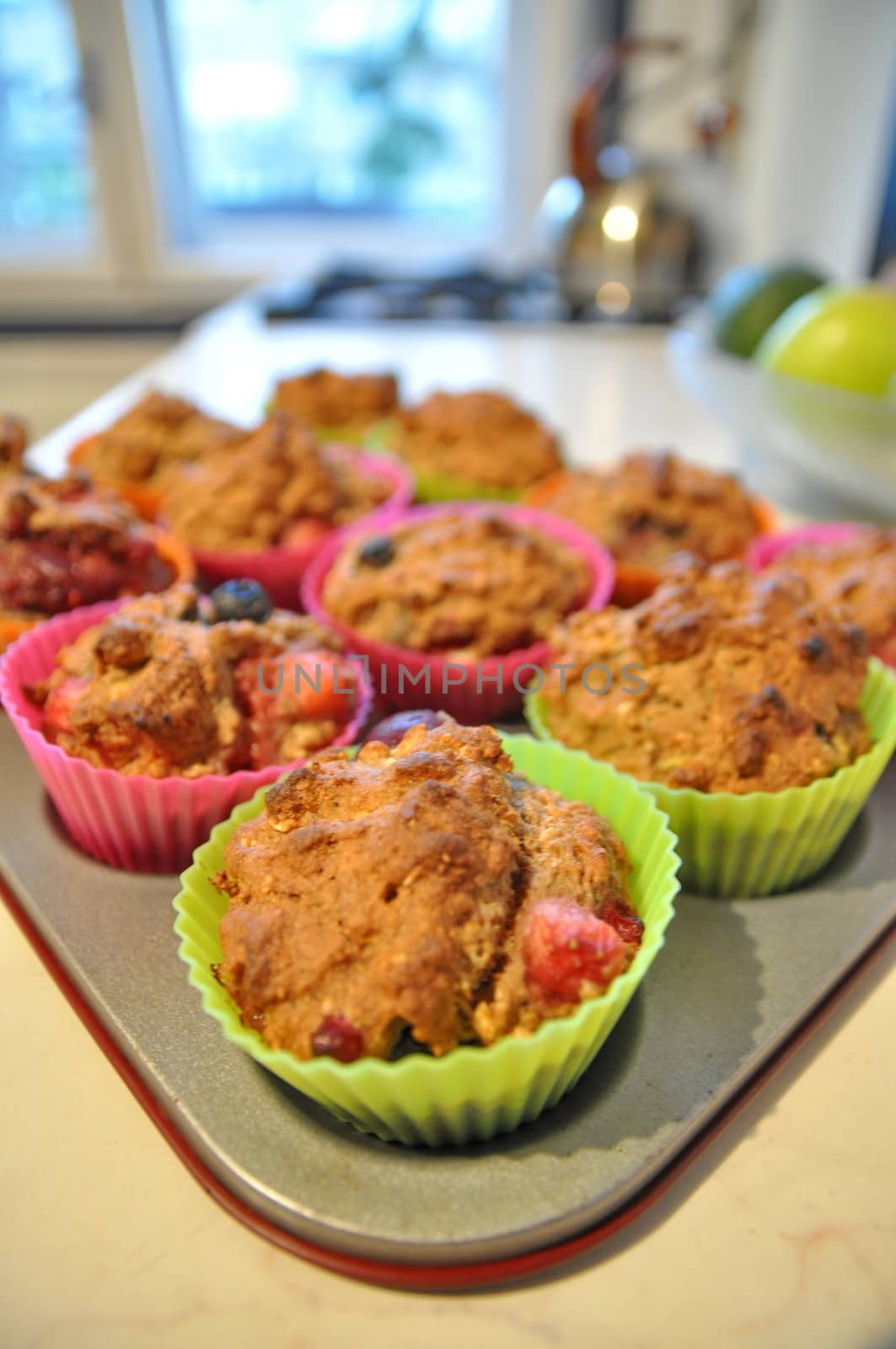 Cooking muffins in colourful plastic cups by anderm