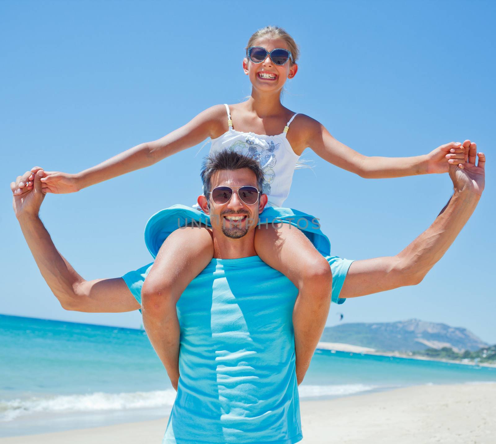 Father and daughter having fun on tropical beach