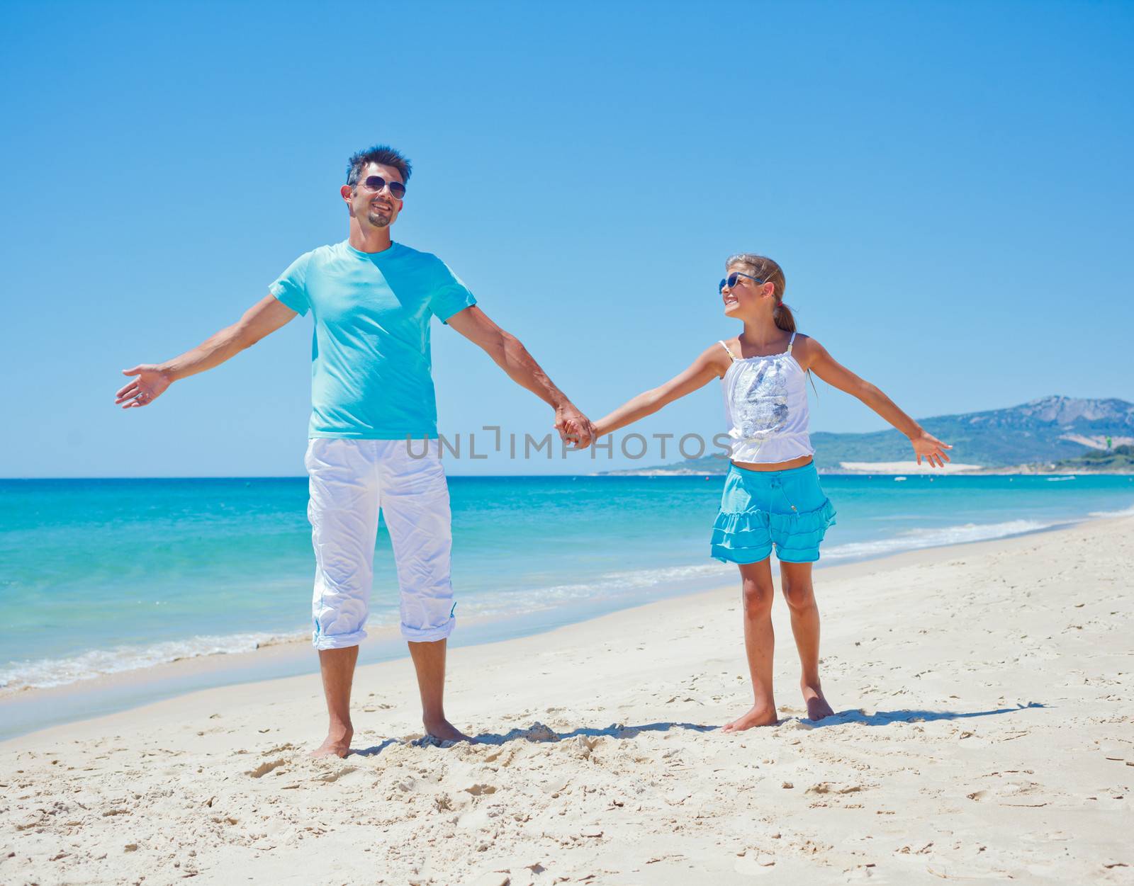 Father and daughter having fun on tropical beach