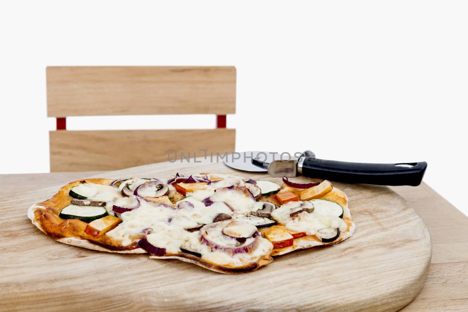 homemade pizza with cutter on small desk in light grey background