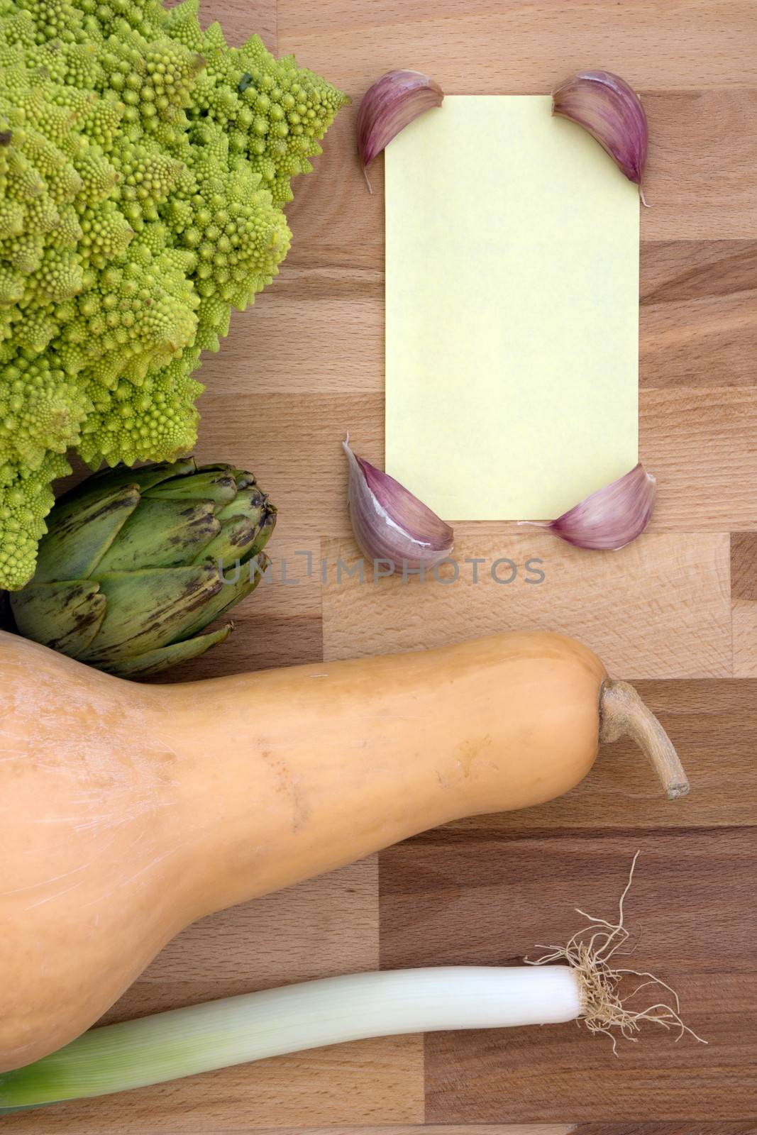 Background of vegetables on a wooden chopping board with a yellow paper for messages.