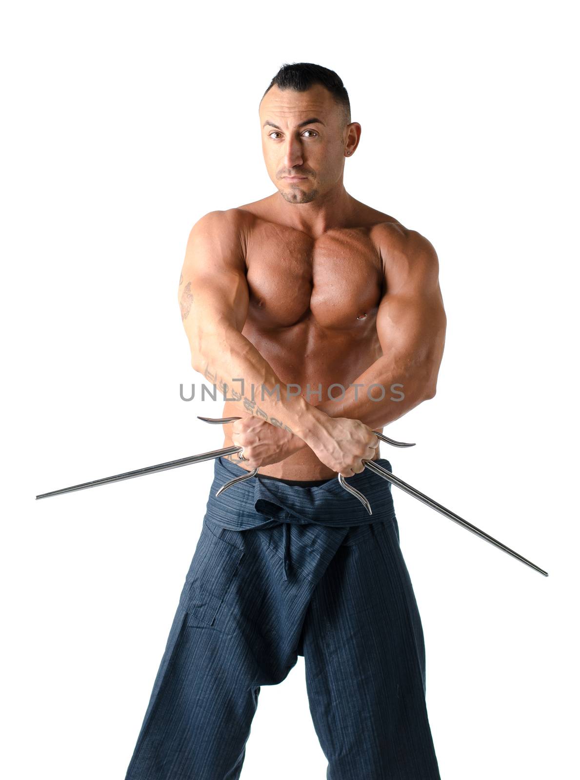 Muscular shirtless man with traditional martial arts daggers, isolated on white