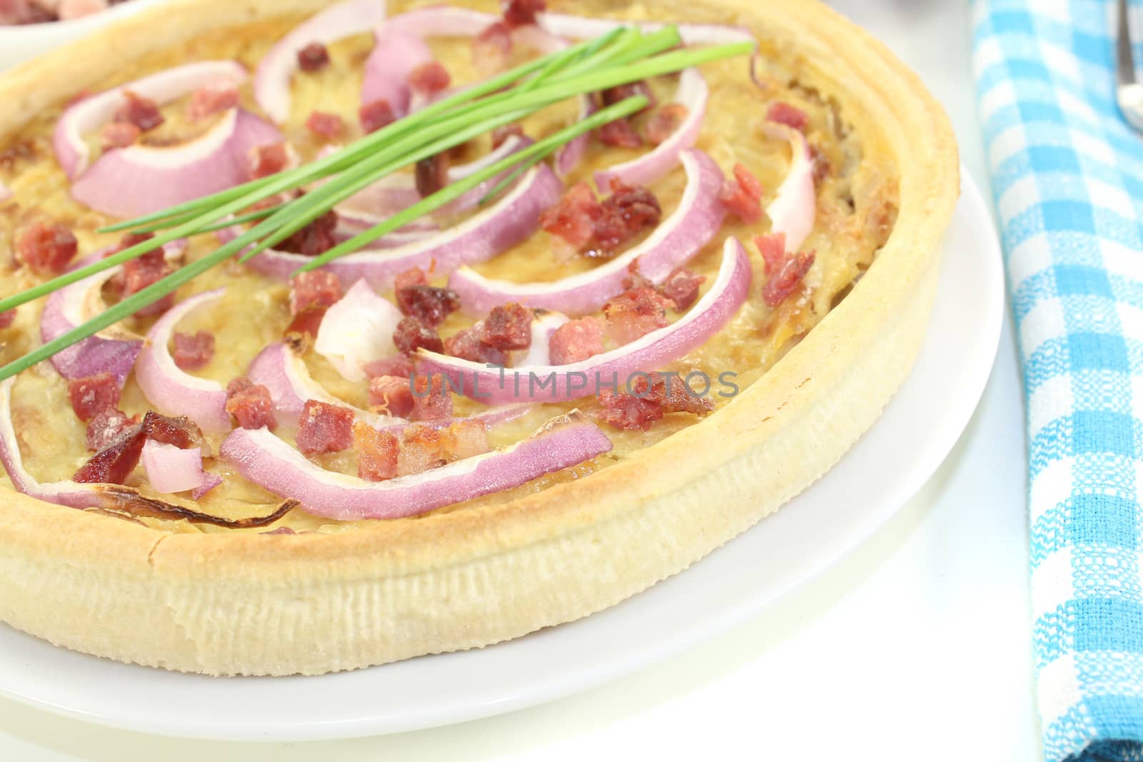 fresh Onion tart with leeks and bacon on a light background