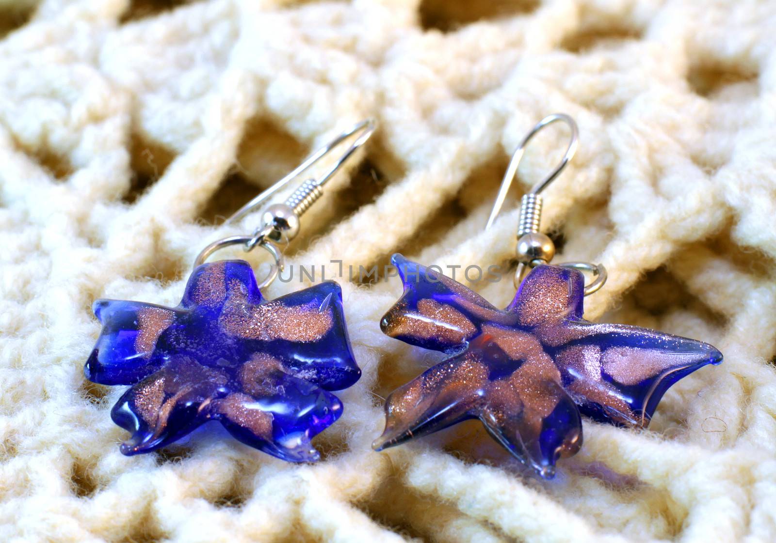 handmade glass flower earrings on the knitted background