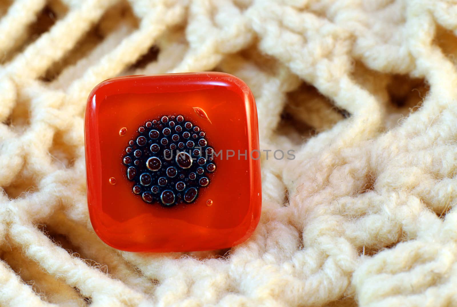 origina red glass handmade ring on knitted background