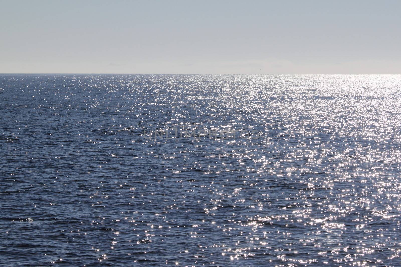 view of blue ocean water with sun reflection on it