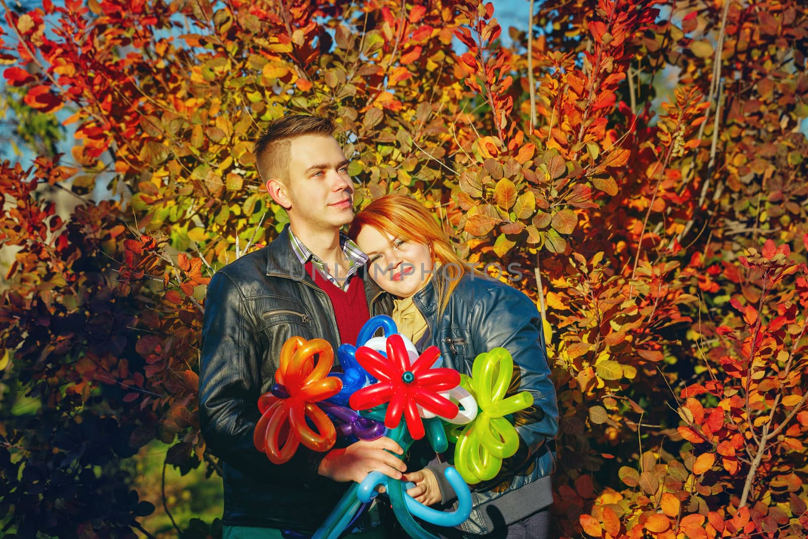 Young couple tenderly and lovingly embrace each other in autumn park