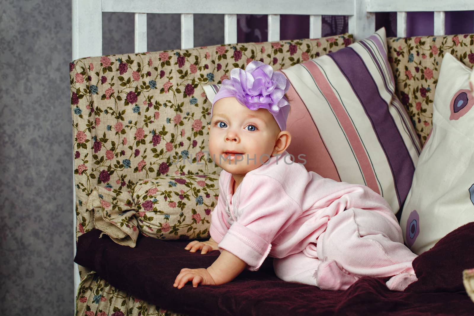 Little girl with bow on her head sitting on couch