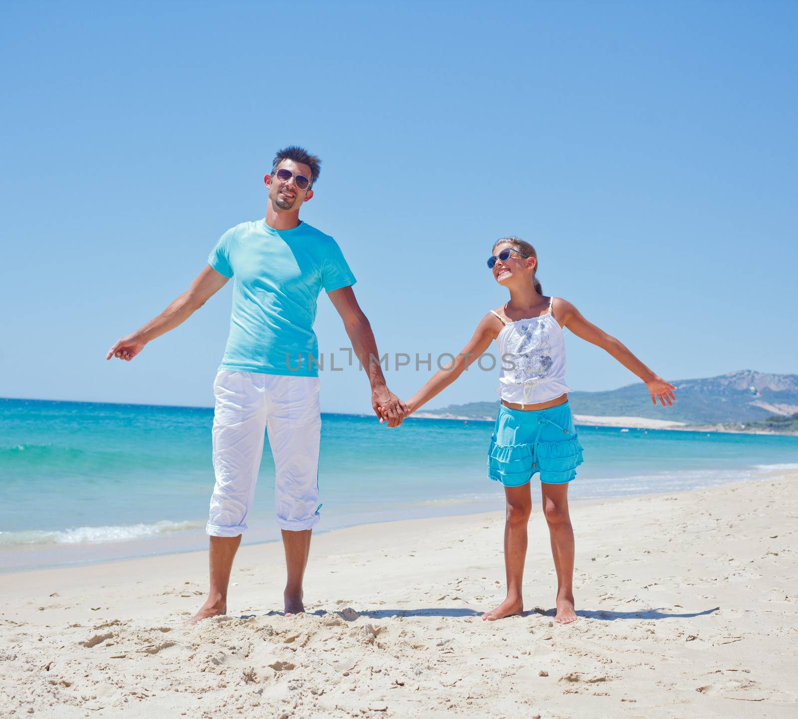 Father and daughter having fun on tropical beach